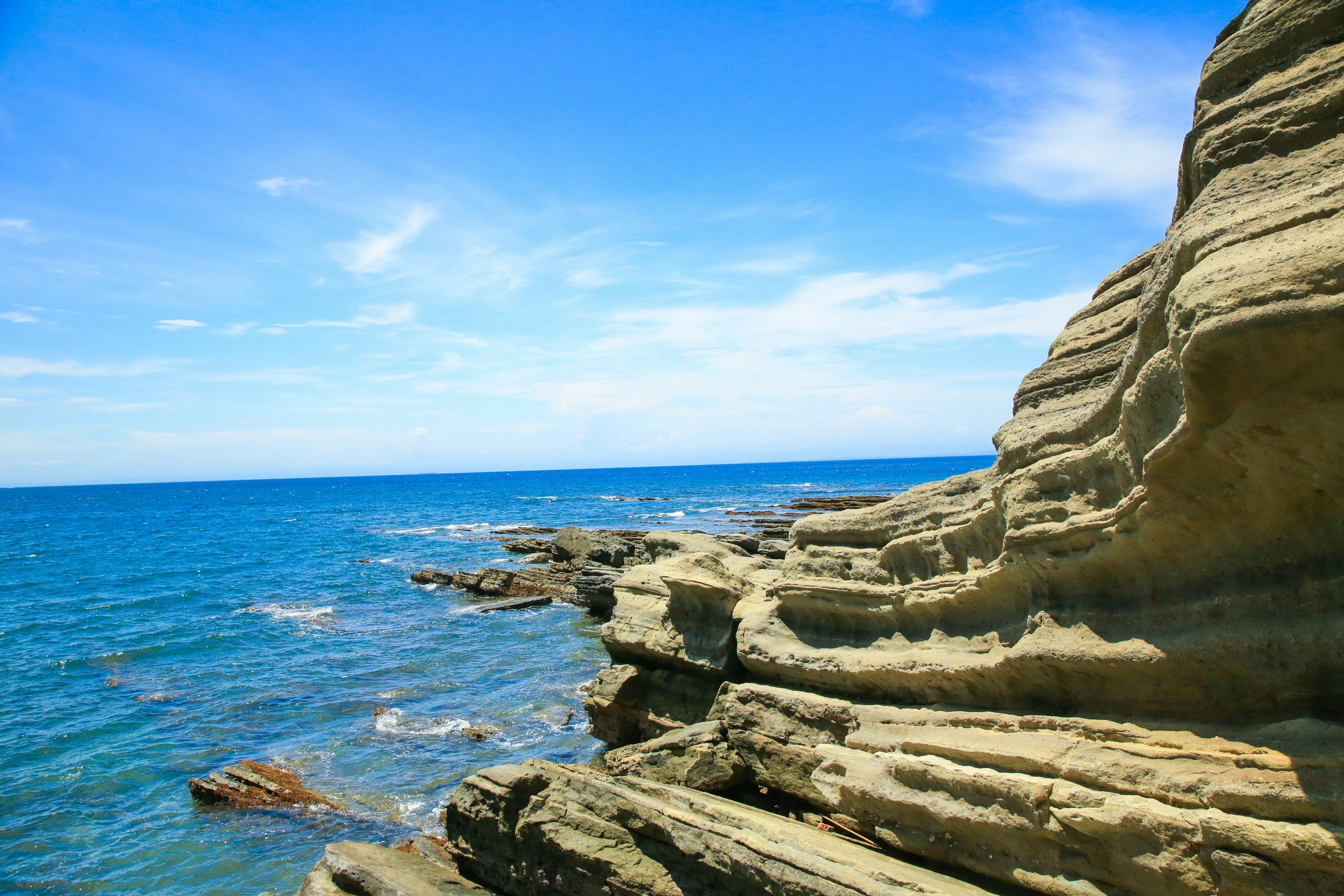 Costa rocosa bajo un cielo azul y un océano