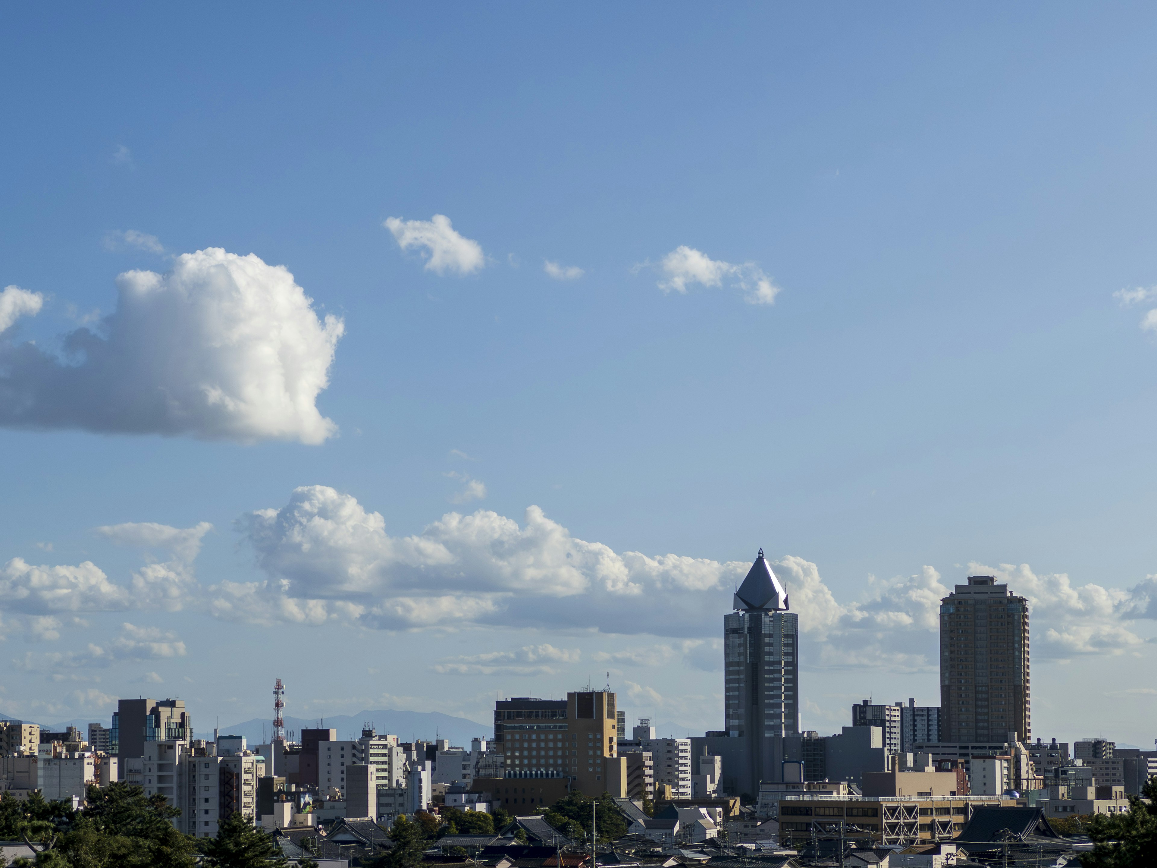 Skyline cittadino con grattacieli sotto un cielo azzurro