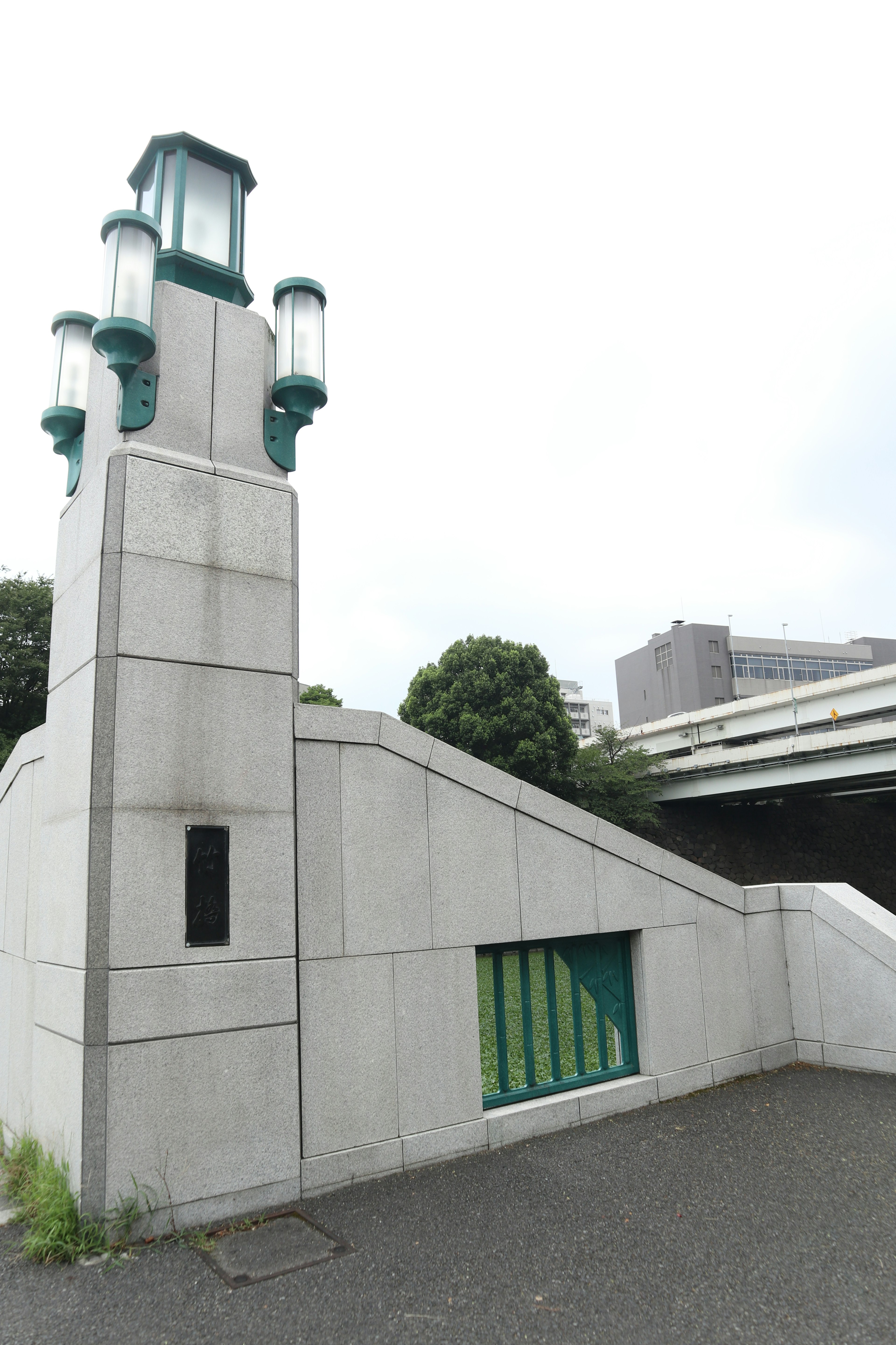 A concrete structure featuring a stairway and a lantern with green accents