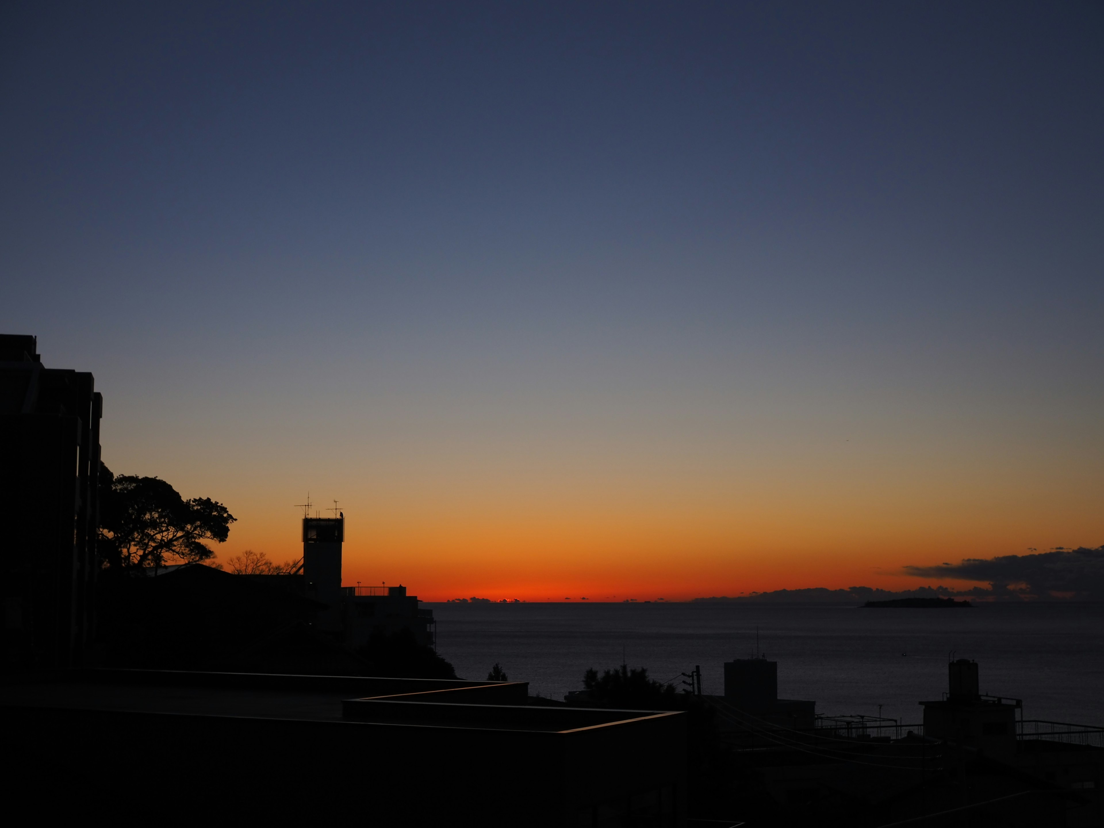 夕焼けの海と建物のシルエットが映る美しい風景