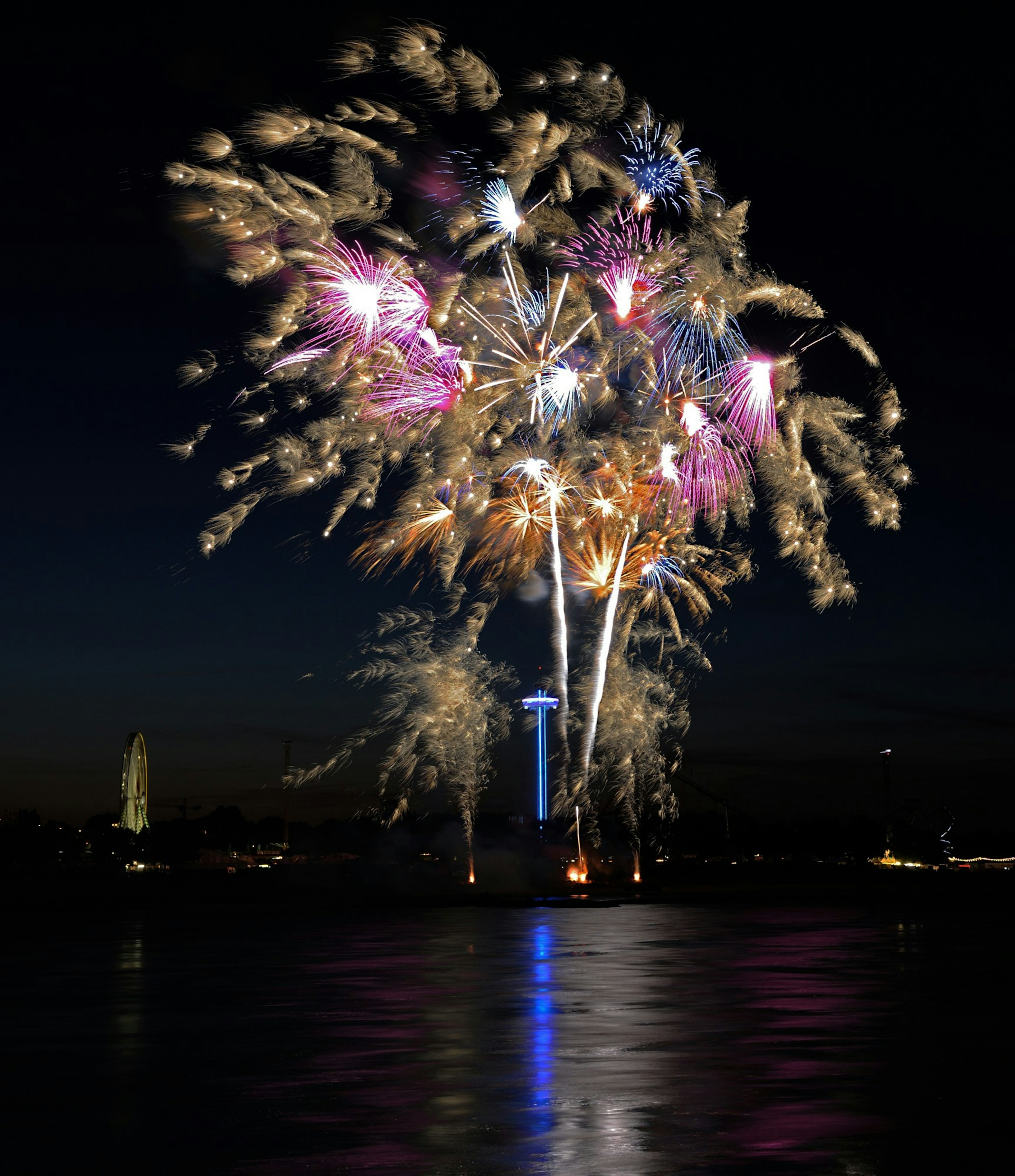 ดอกไม้ไฟหลากสีสันส่องสว่างในยามค่ำคืนพร้อมกับ Space Needle ของซีแอตเทิลในพื้นหลัง