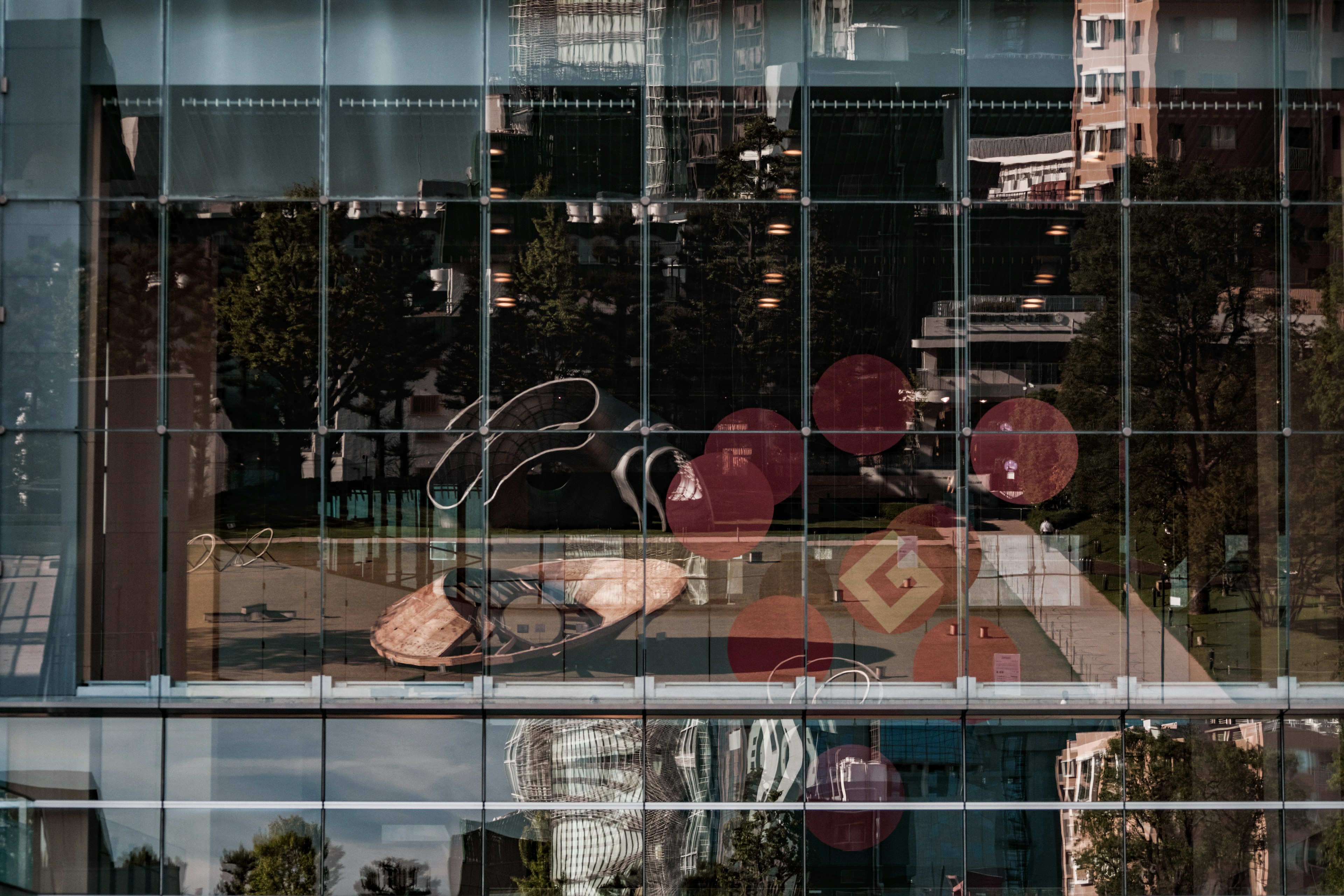 Colorful art and scenery reflected in a building's window