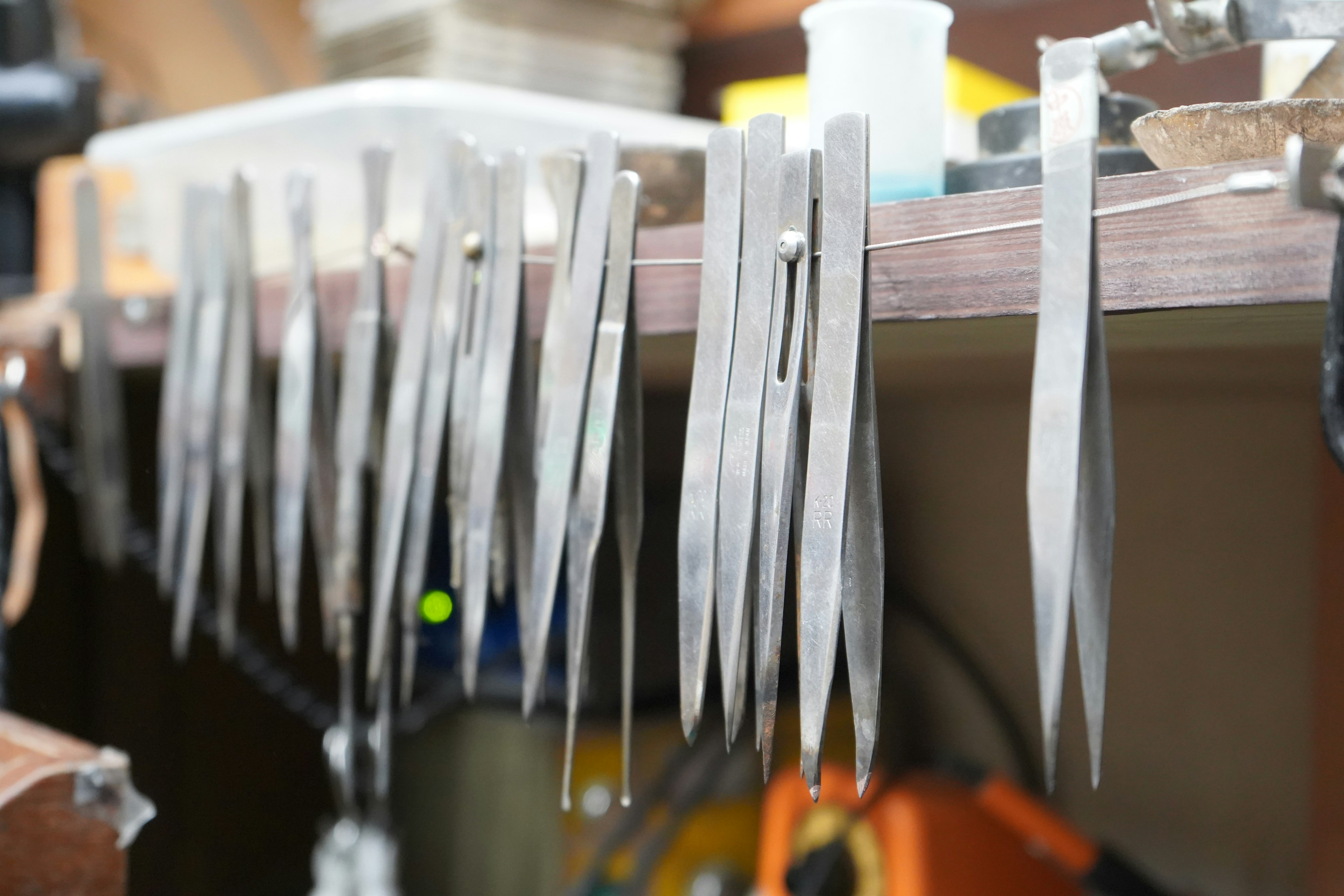 Image of metal tweezers neatly arranged on a workbench