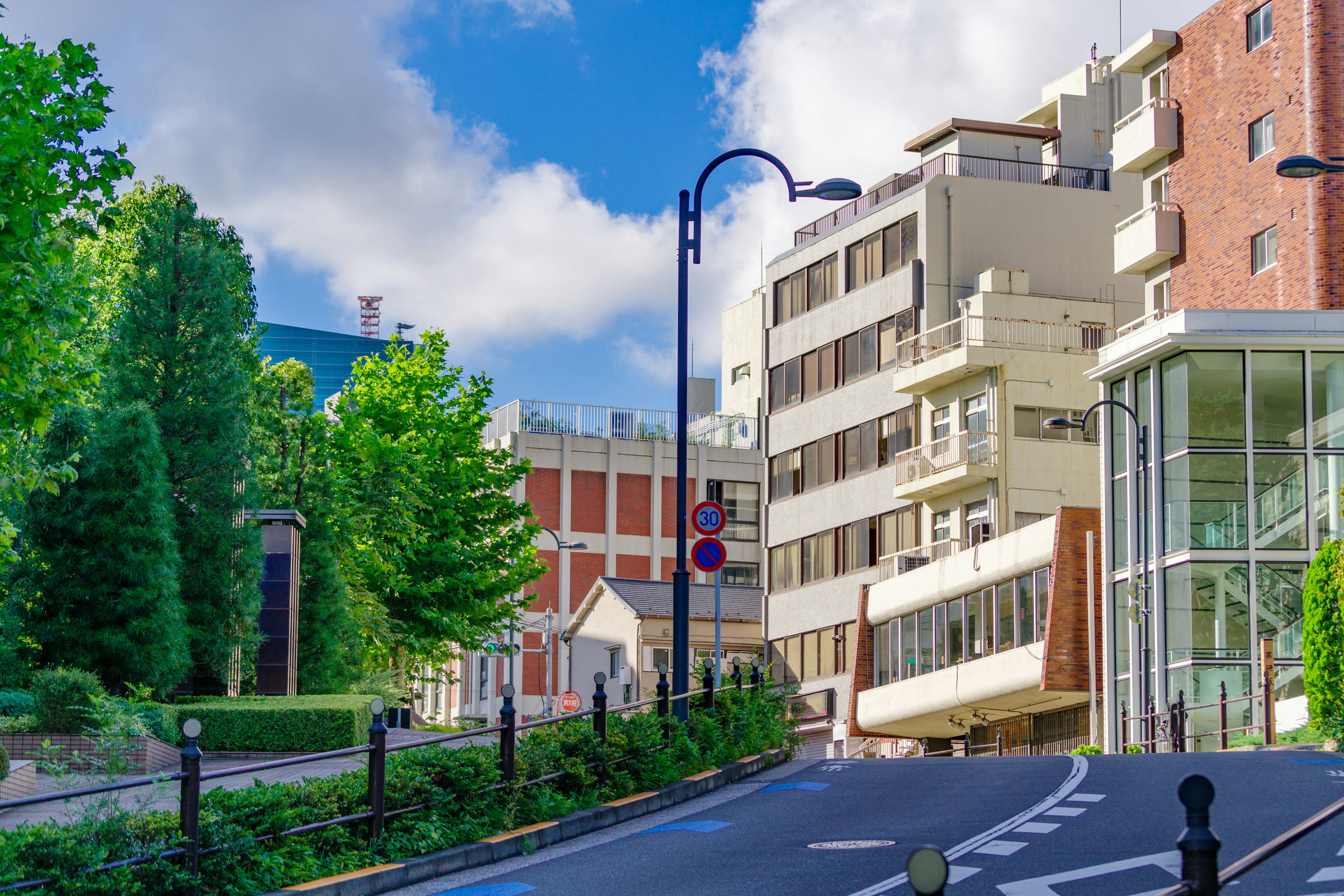 Vista escénica de edificios modernos y vegetación a lo largo de una carretera sinuosa