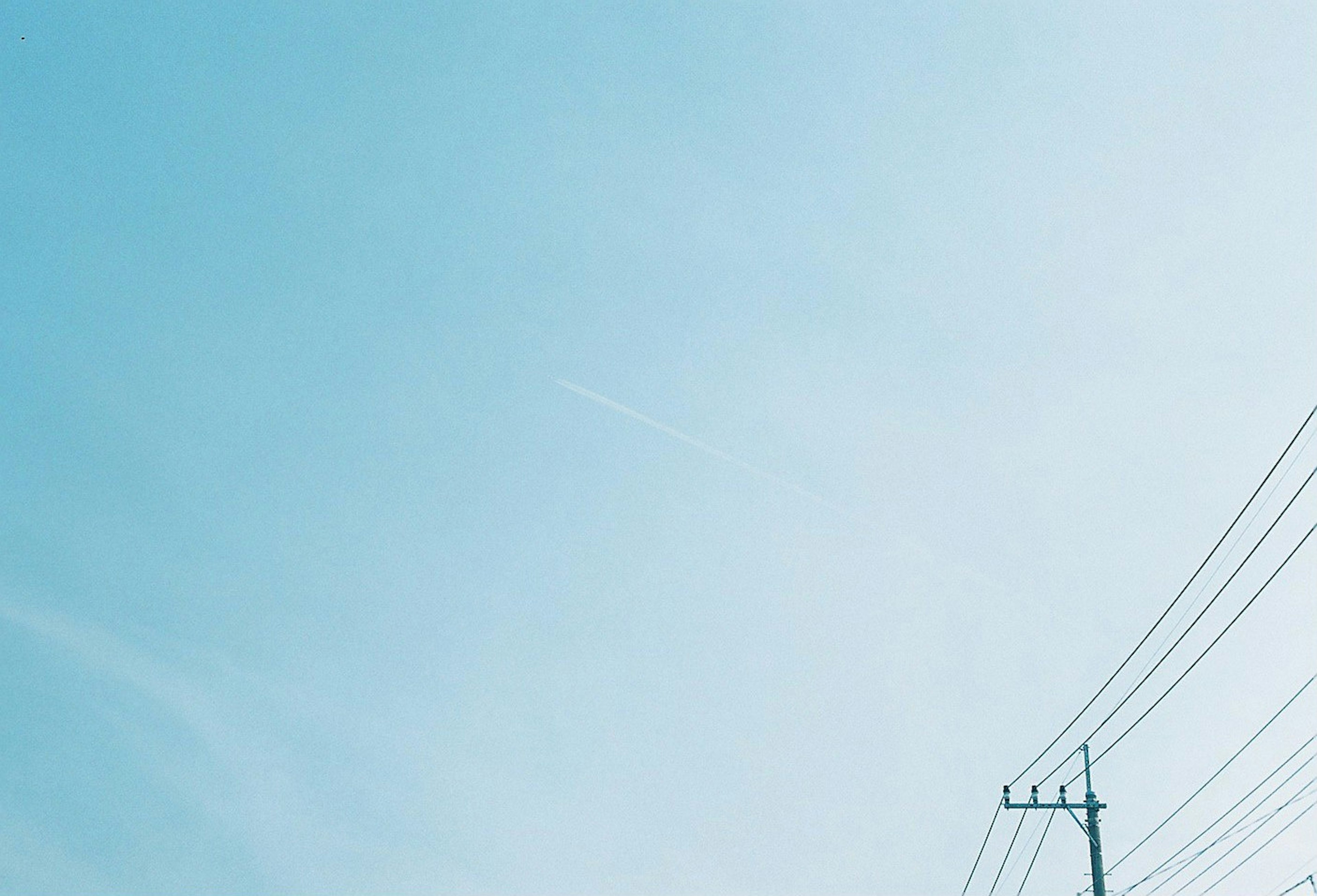 Ciel bleu clair avec des lignes électriques visibles