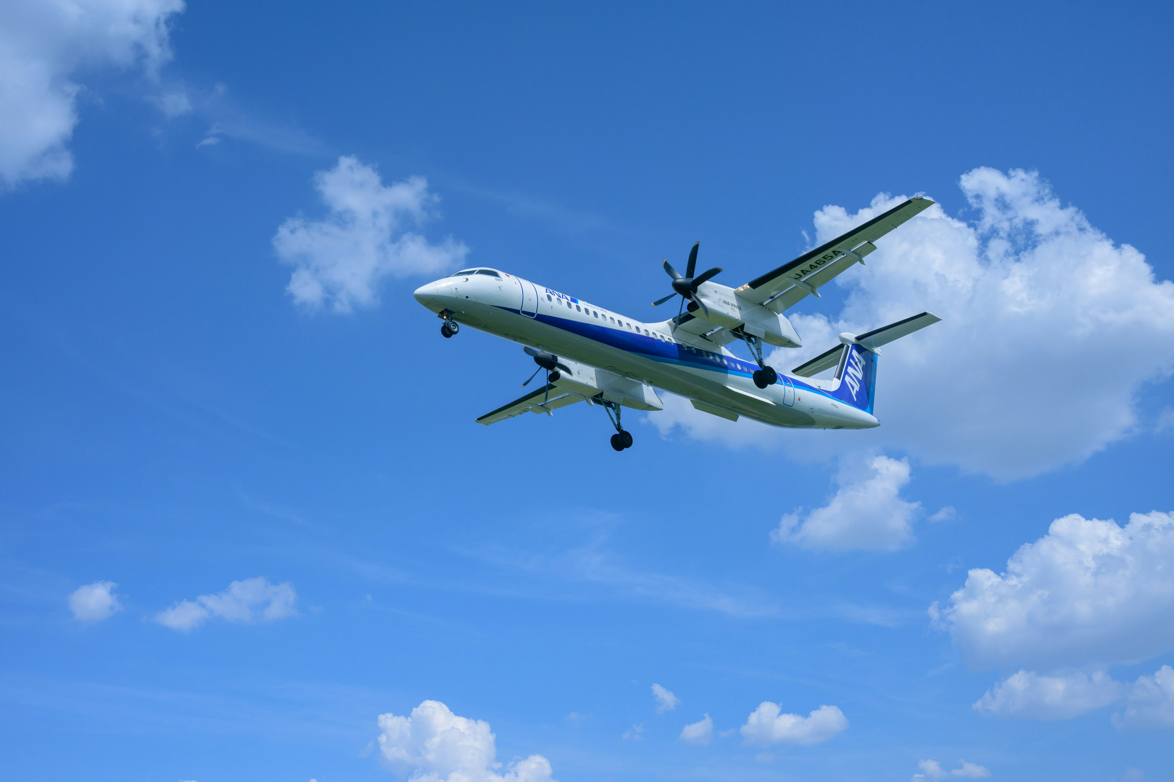 Ein Flugzeug fliegt in einem blauen Himmel mit Wolken