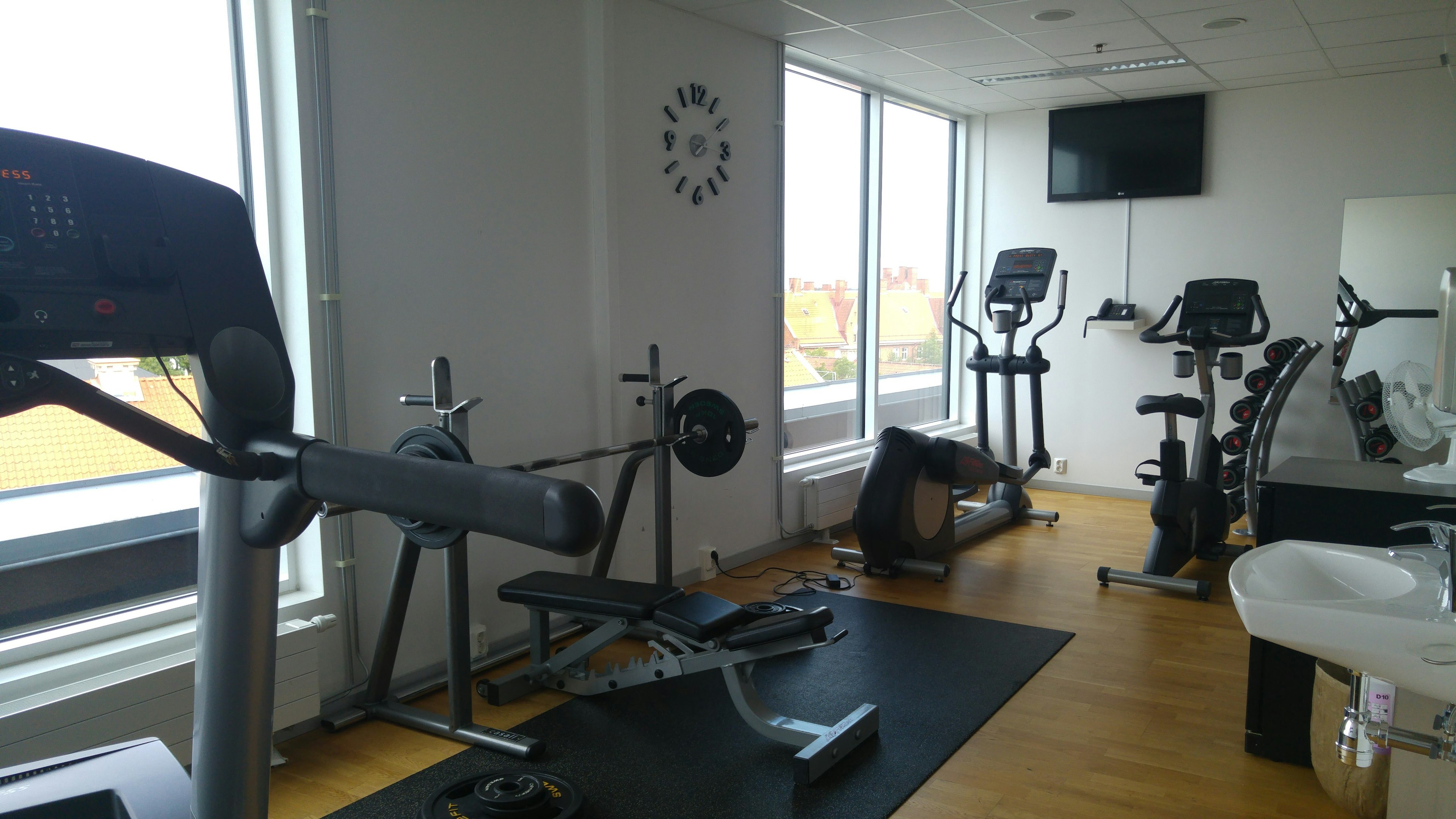 Bright fitness room featuring a treadmill and exercise bikes