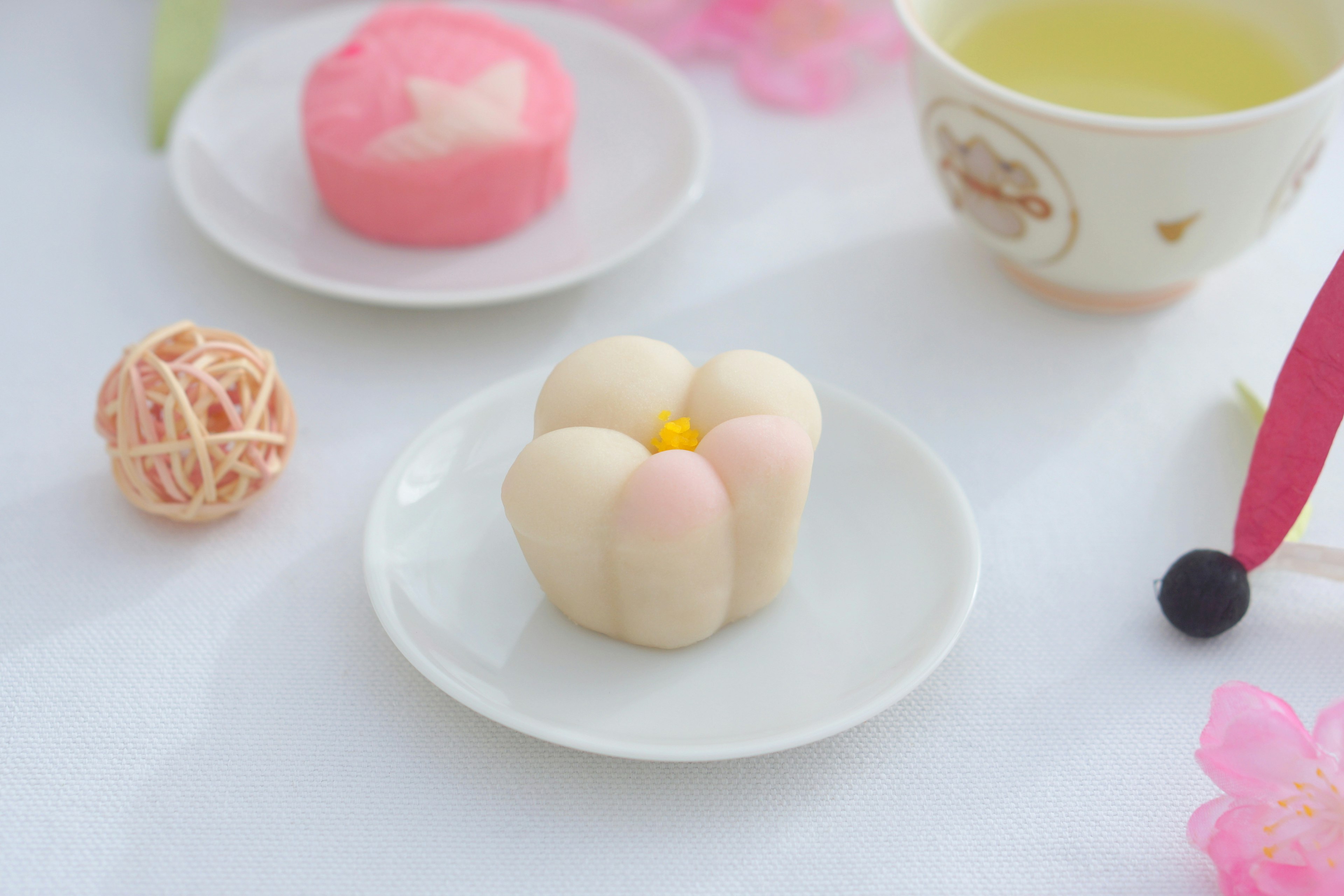 Niedliche blütenförmige Wagashi und rosa Wagashi auf einem Teller