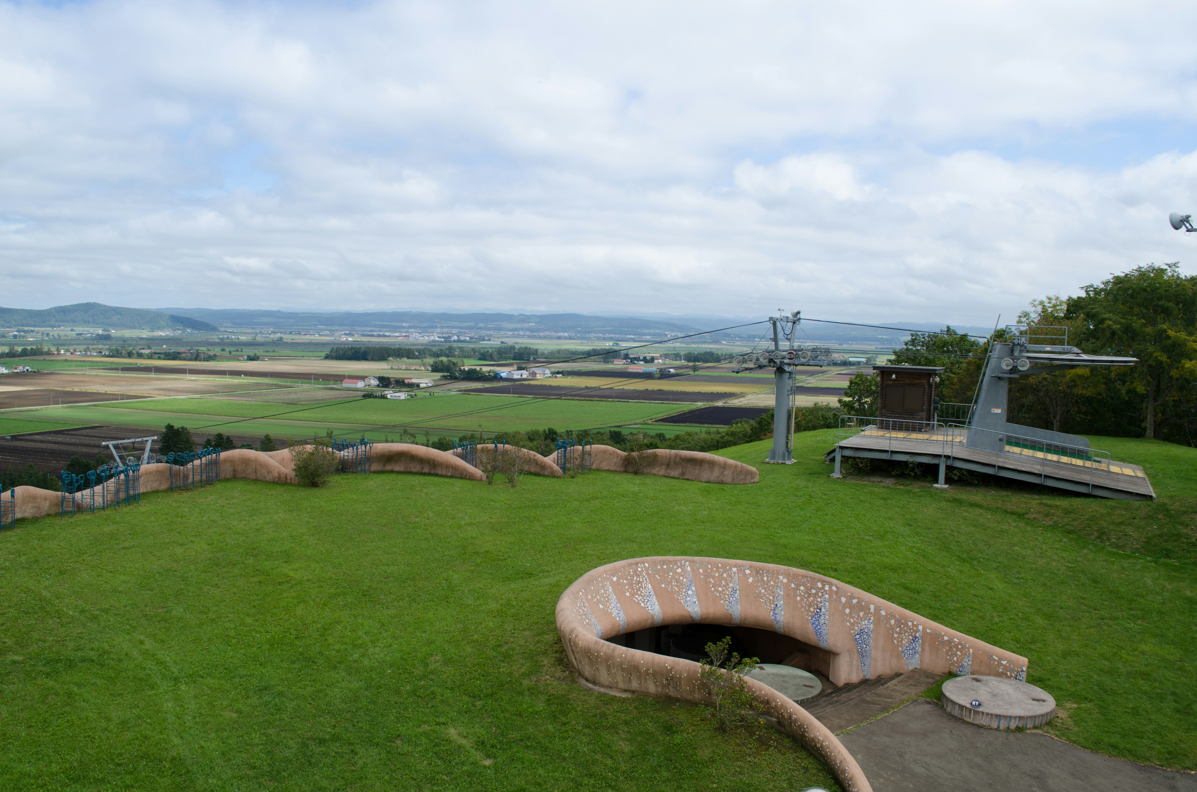 Panoramablick auf einen Park mit einer weitläufigen grünen Landschaft und Spielgeräten