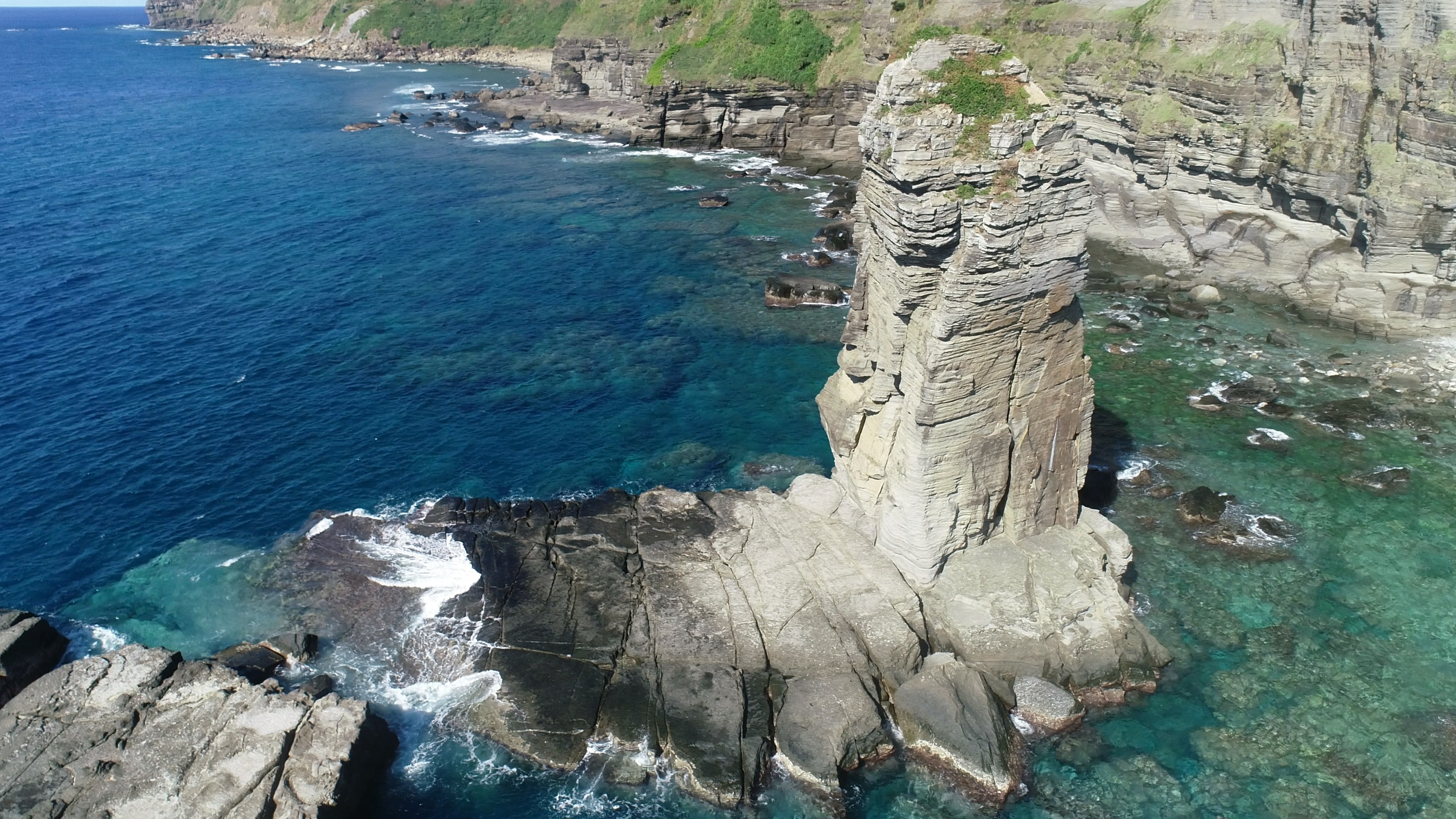 Vue côtière pittoresque avec un rocher et des eaux cristallines