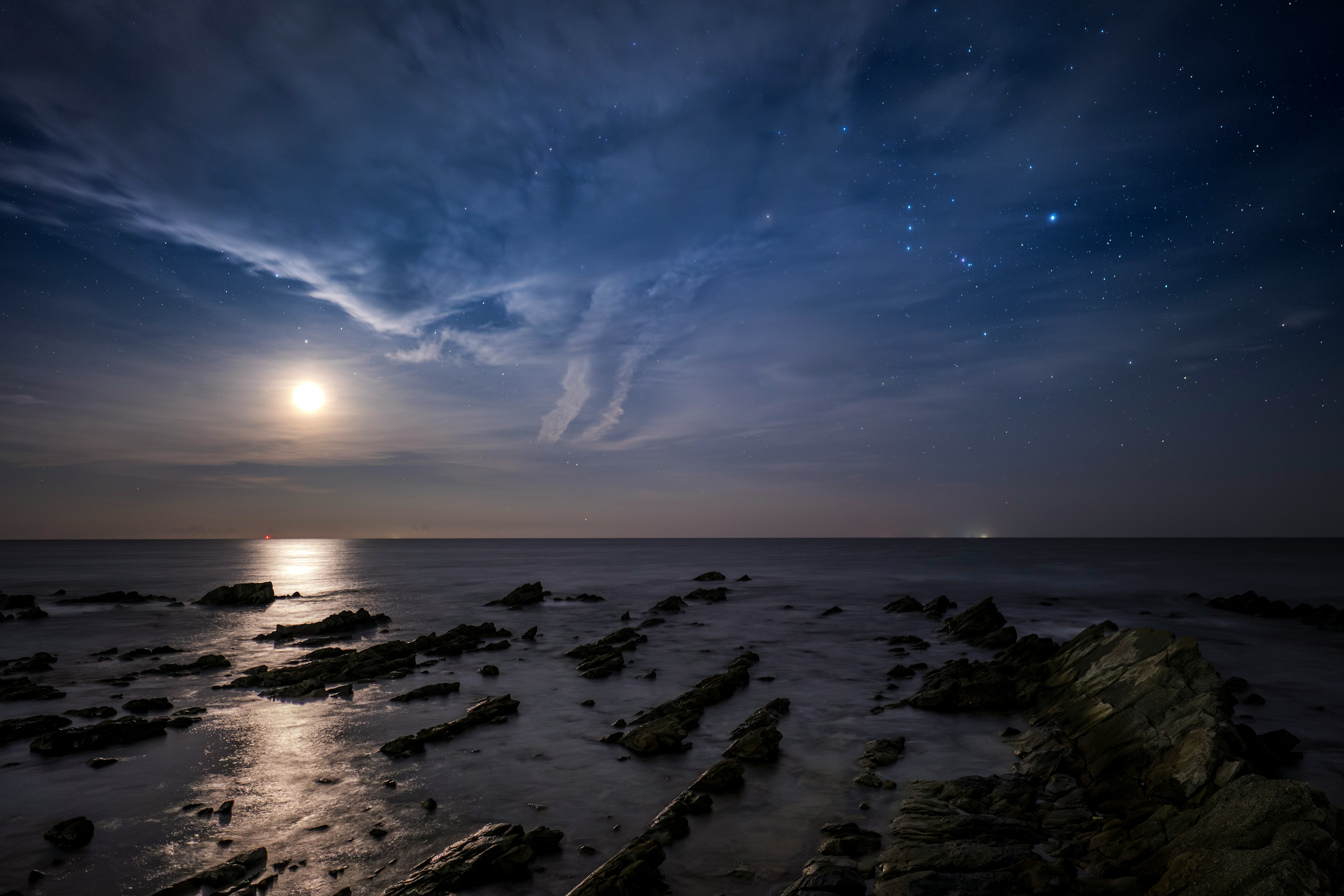 Paysage côtier sous un ciel étoilé avec la lumière de la lune