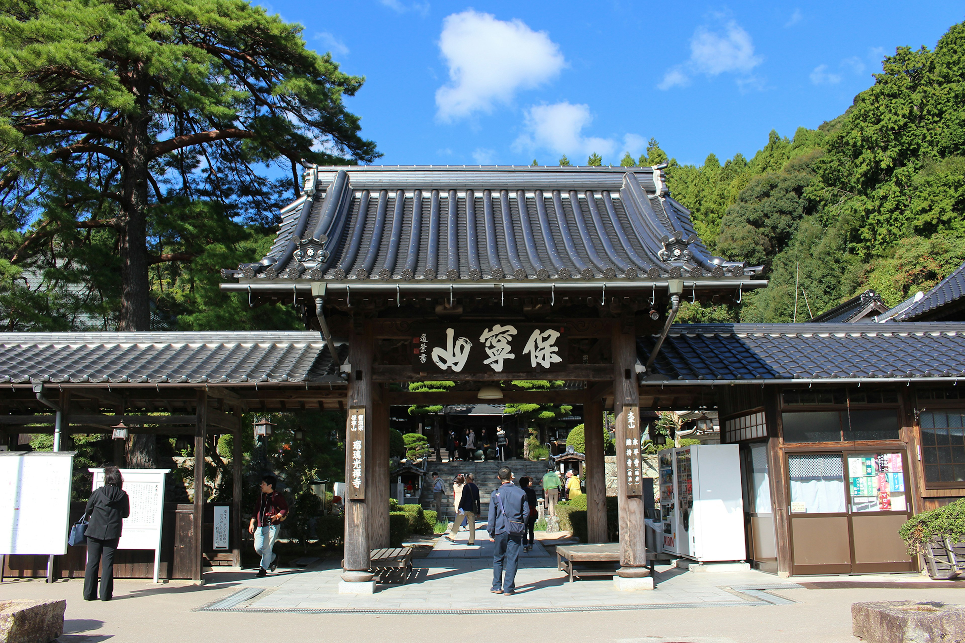 Traditional temple gate with visitors under a blue sky