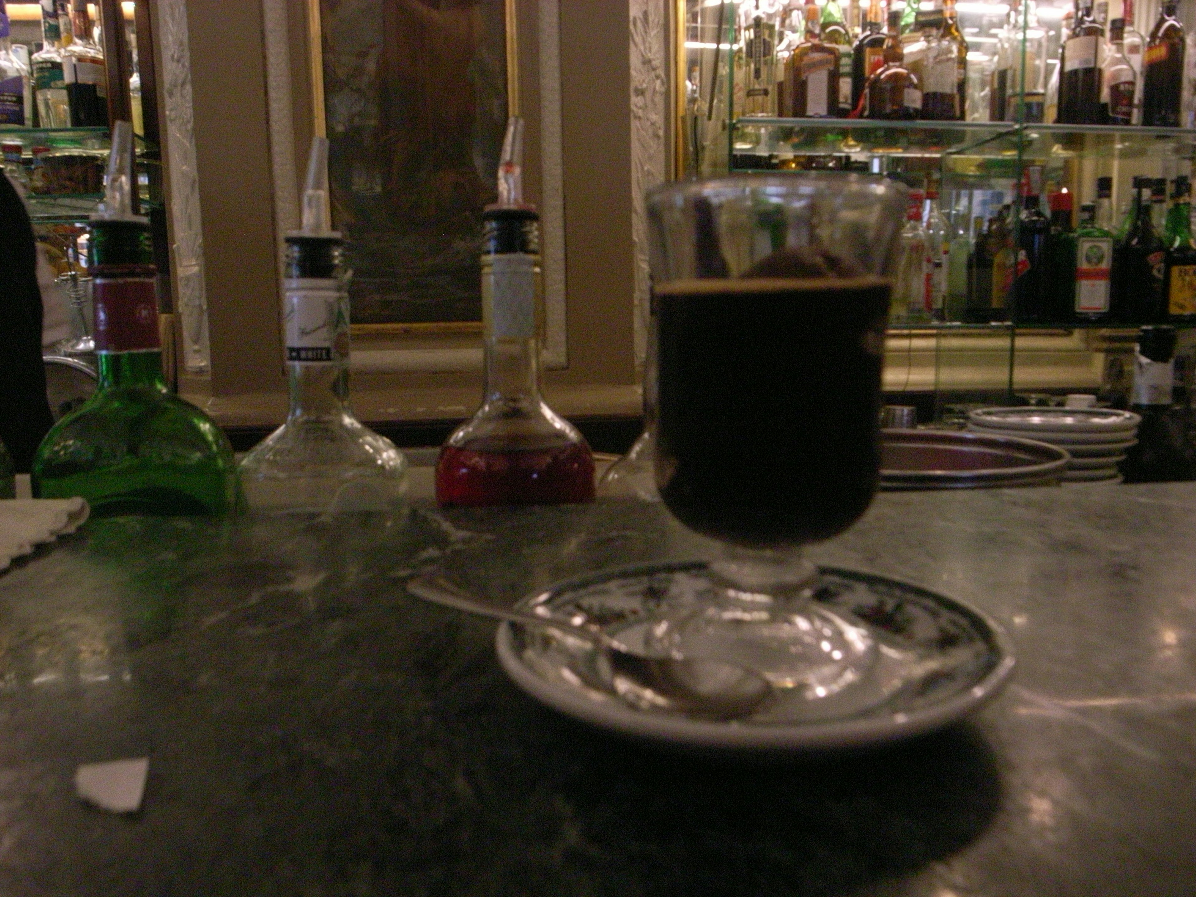 Un verre de café sur un comptoir de bar avec une cuillère