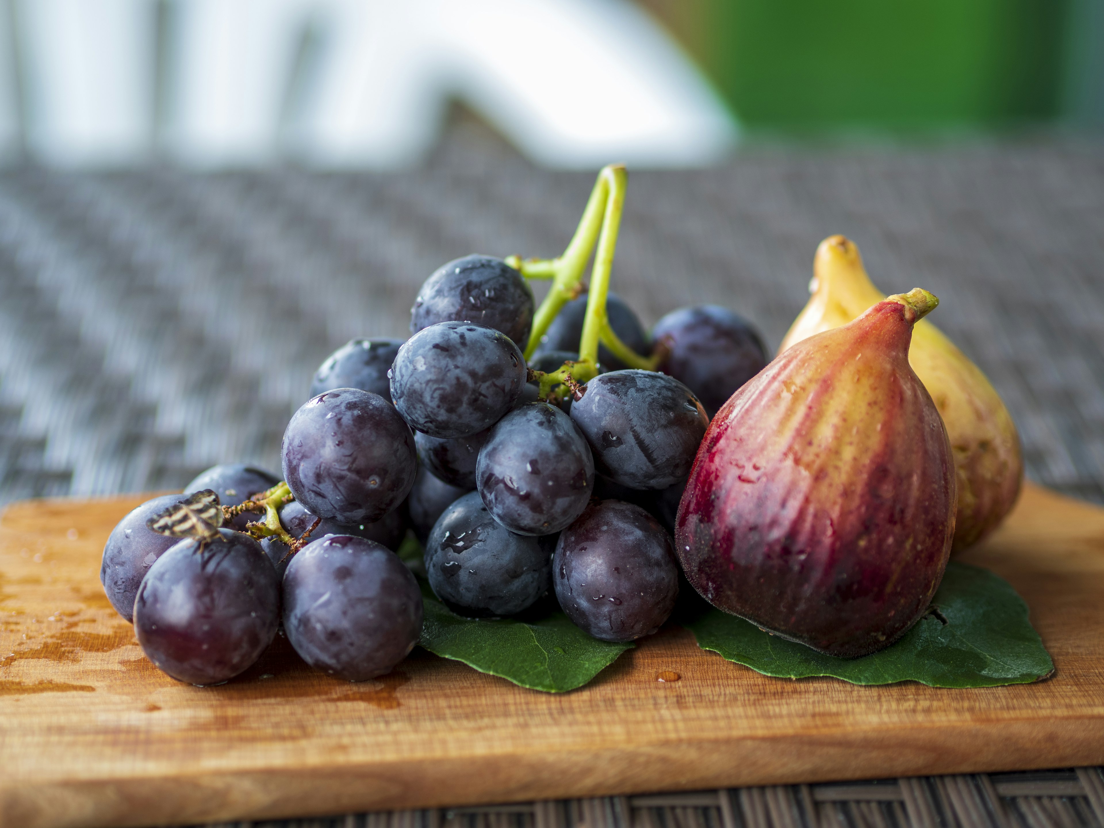 Una exhibición de uvas y higos sobre una tabla de madera