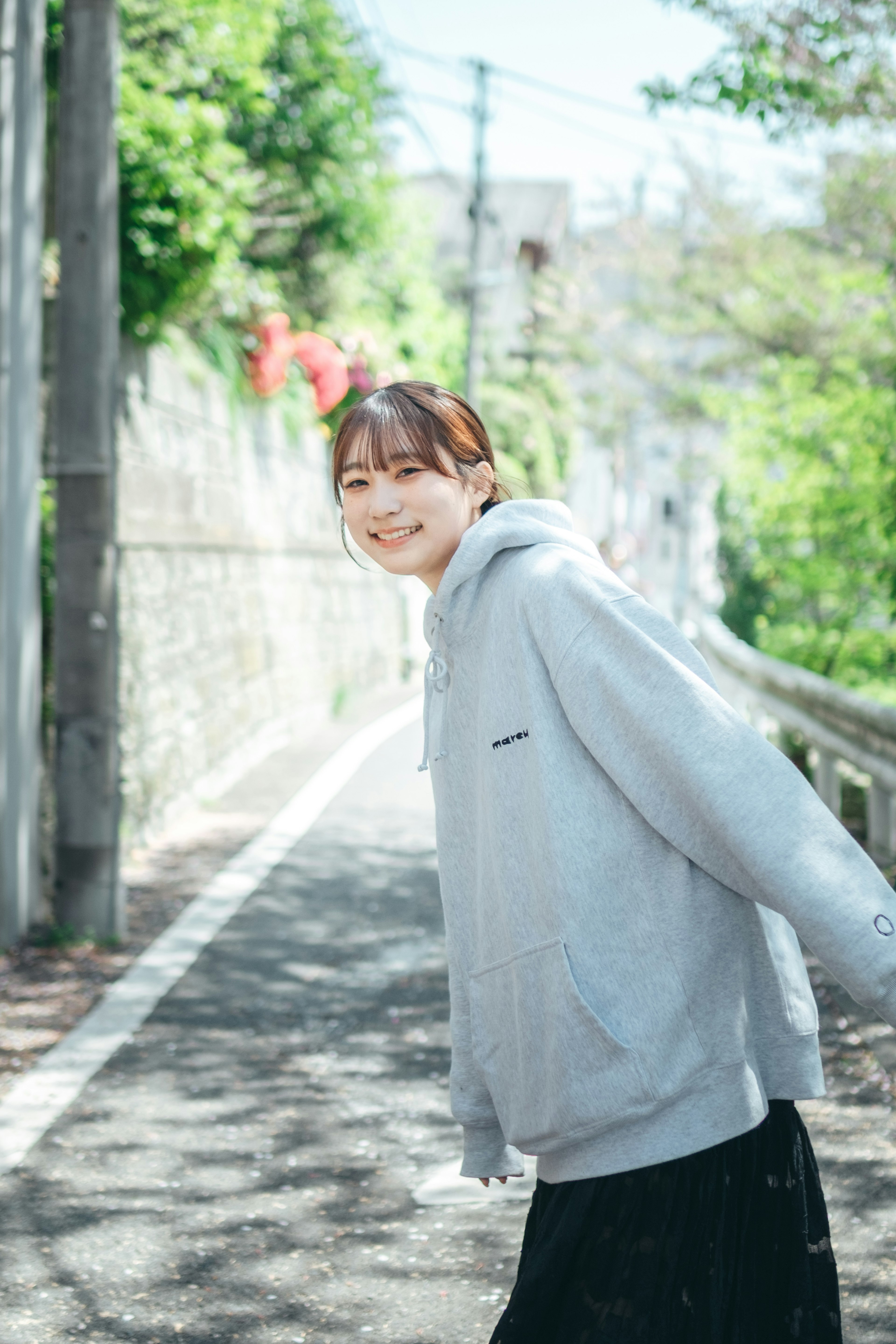 A smiling woman walking in a sunny outdoor setting