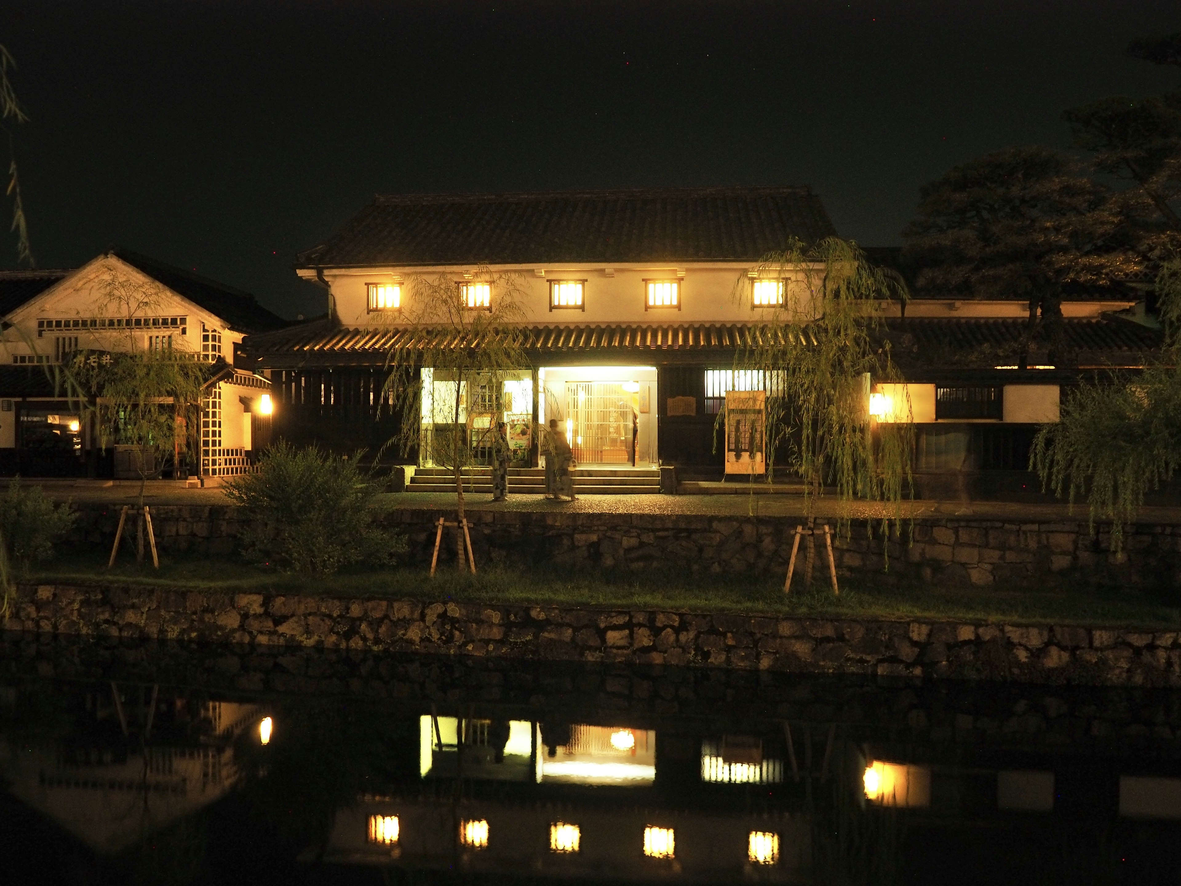 夜の静かな川沿いにある伝統的な日本家屋の風景