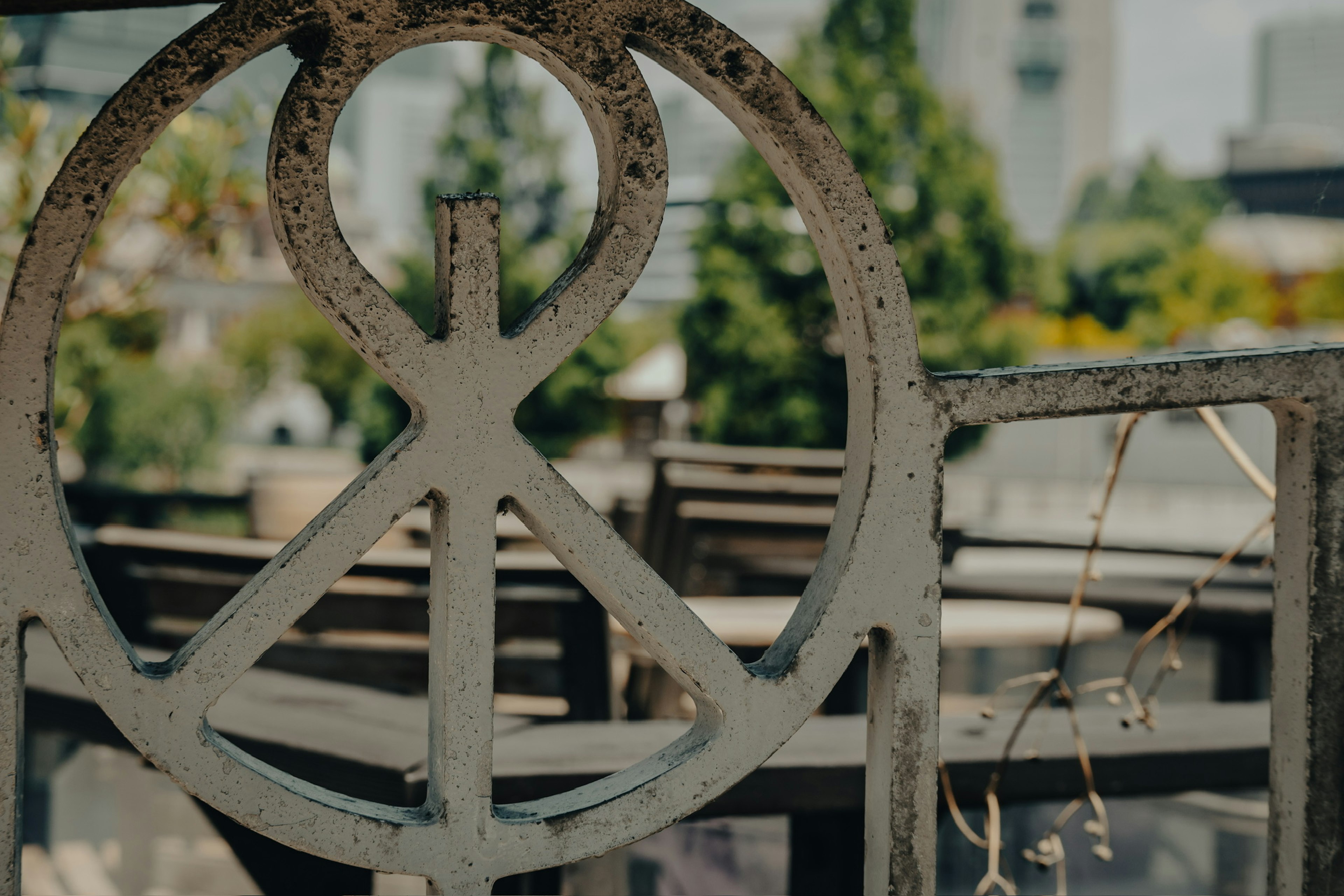 Metal peace symbol with blurred background of trees