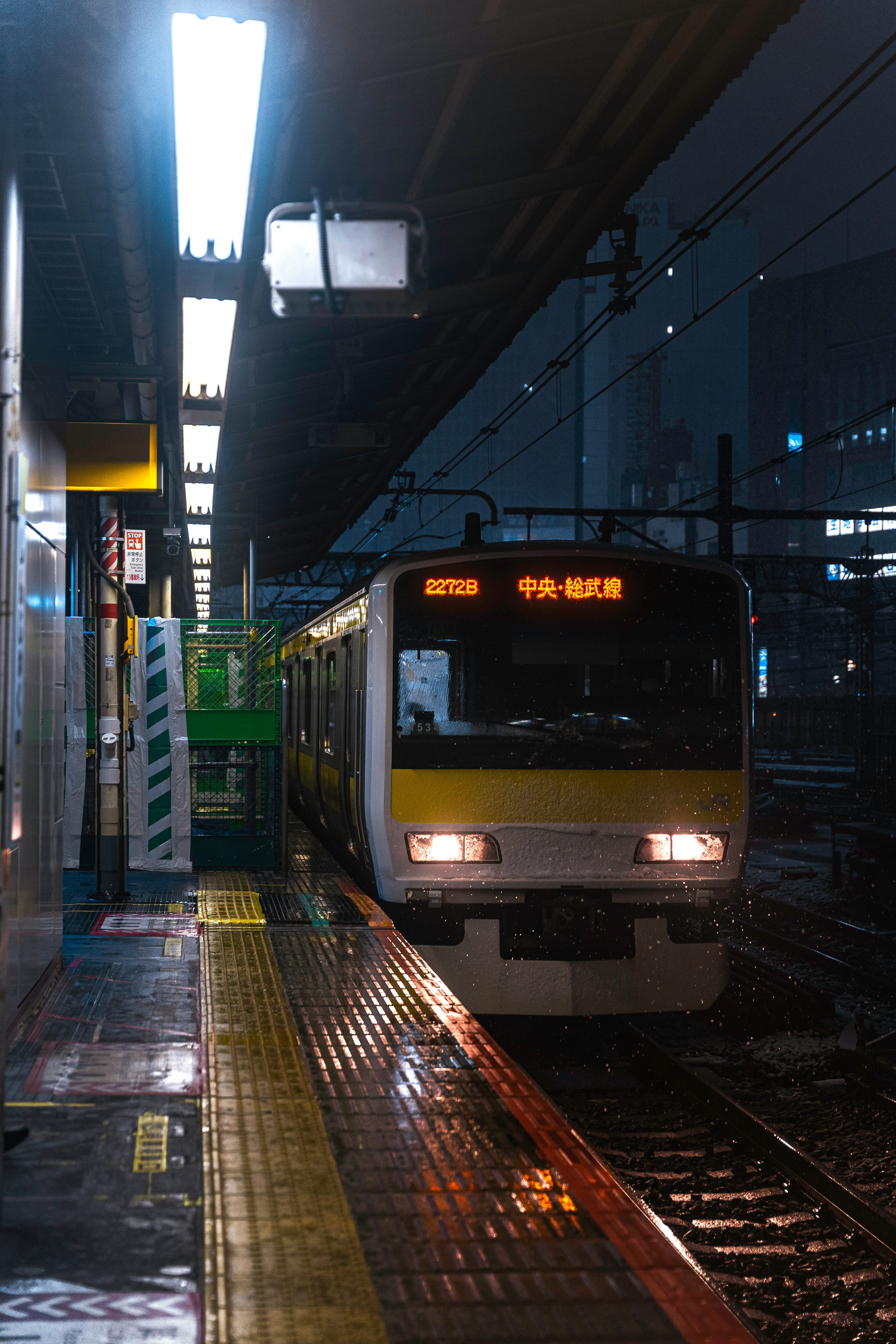 Train arrêté à une station pendant la nuit avec un quai bien éclairé