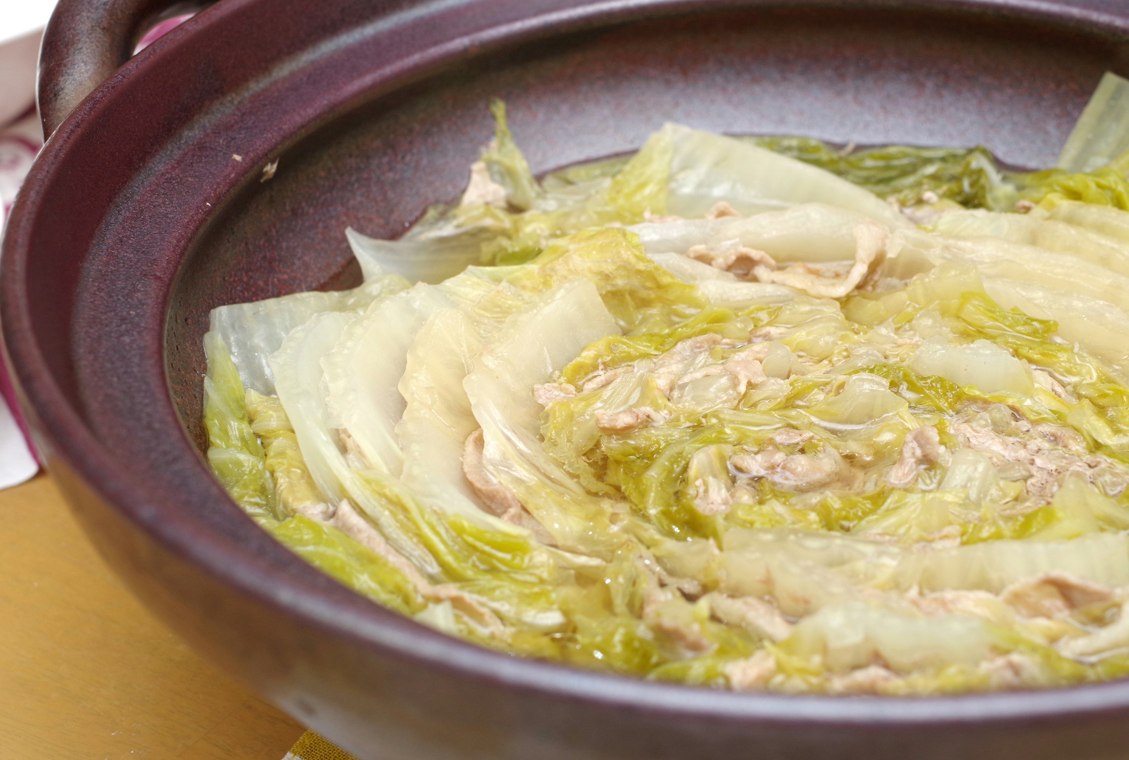 Dish of cabbage leaves and chicken arranged in a pot