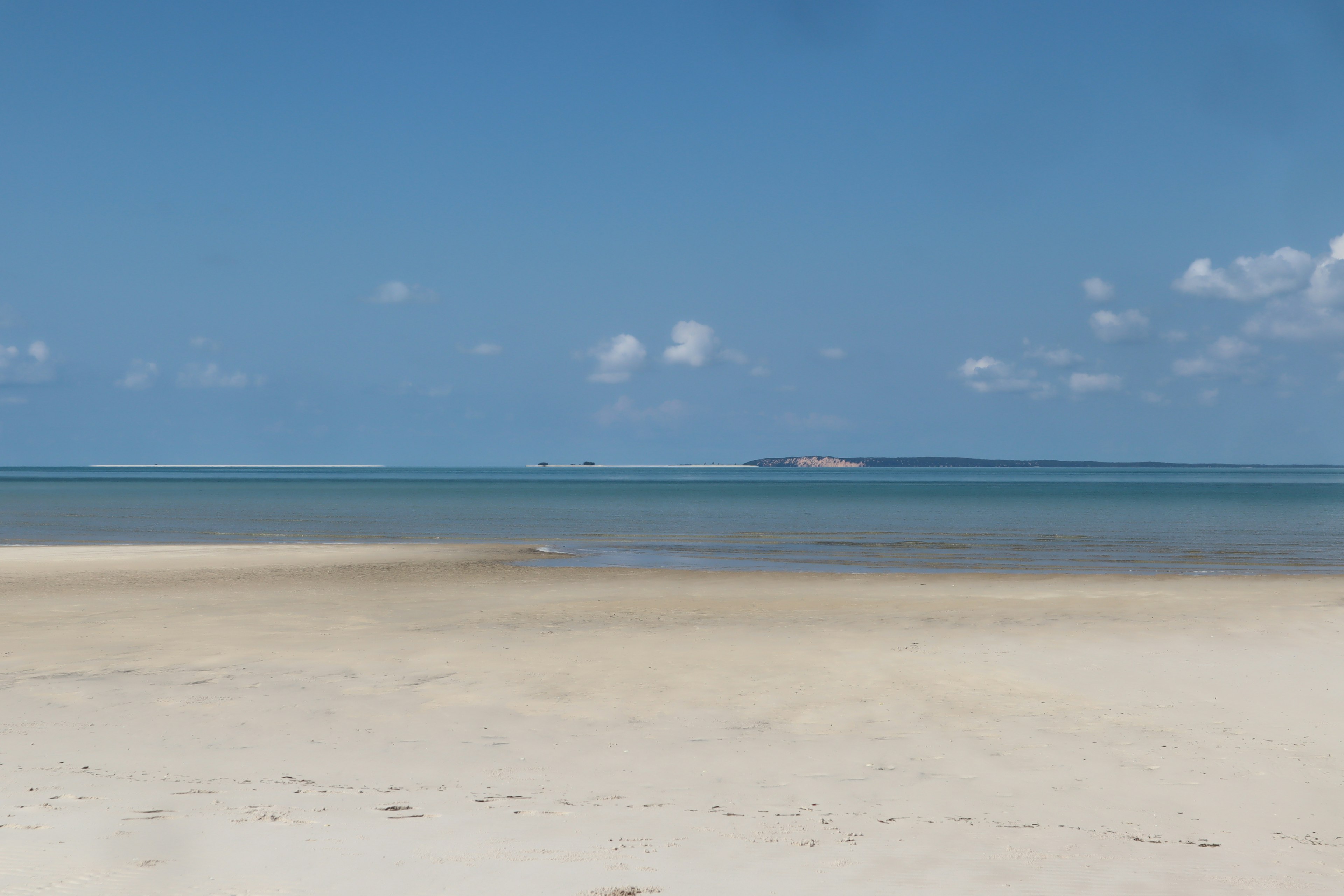 Pemandangan pantai dengan langit biru dan laut tenang