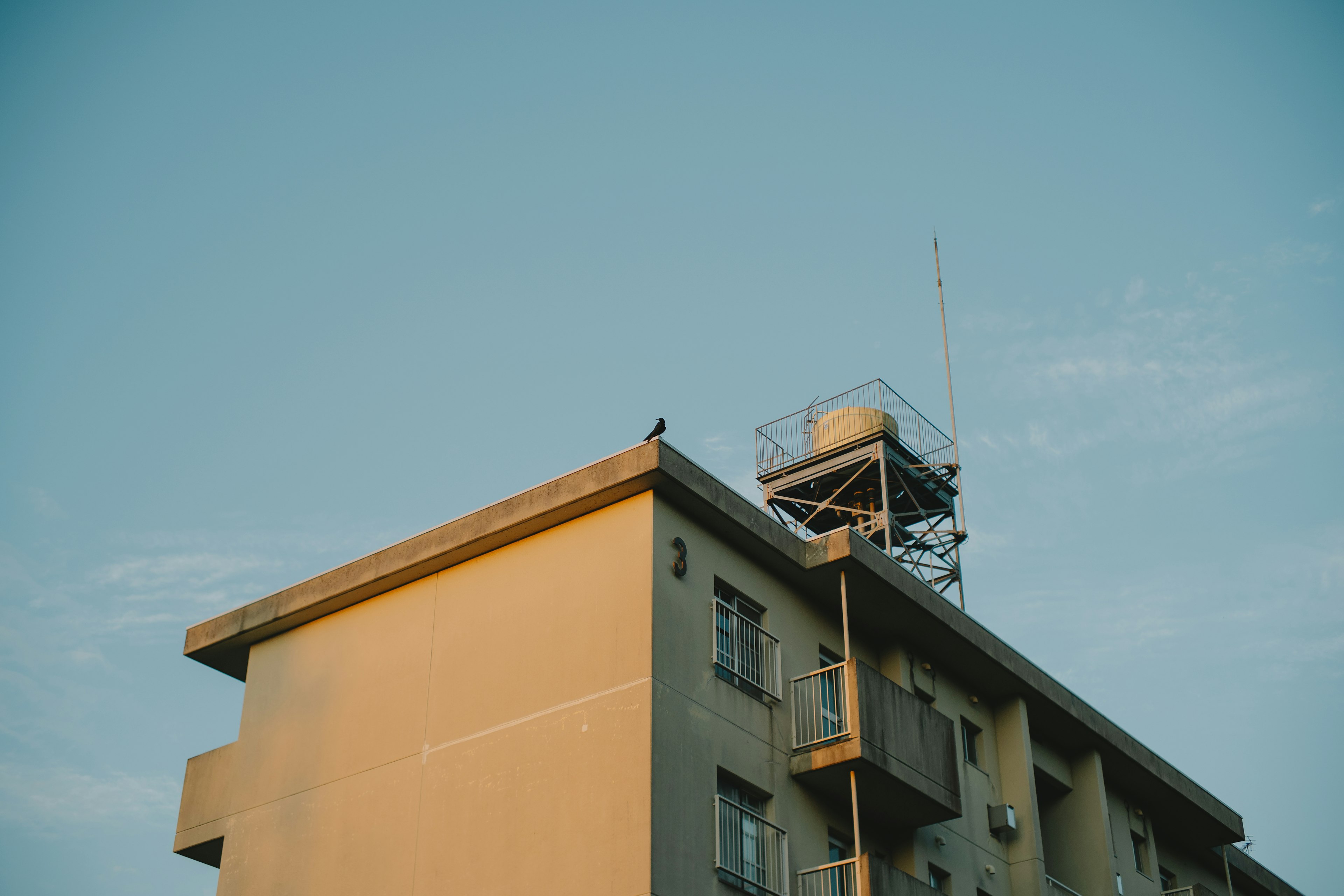 Haut d'un bâtiment avec équipement de communication sous un ciel bleu