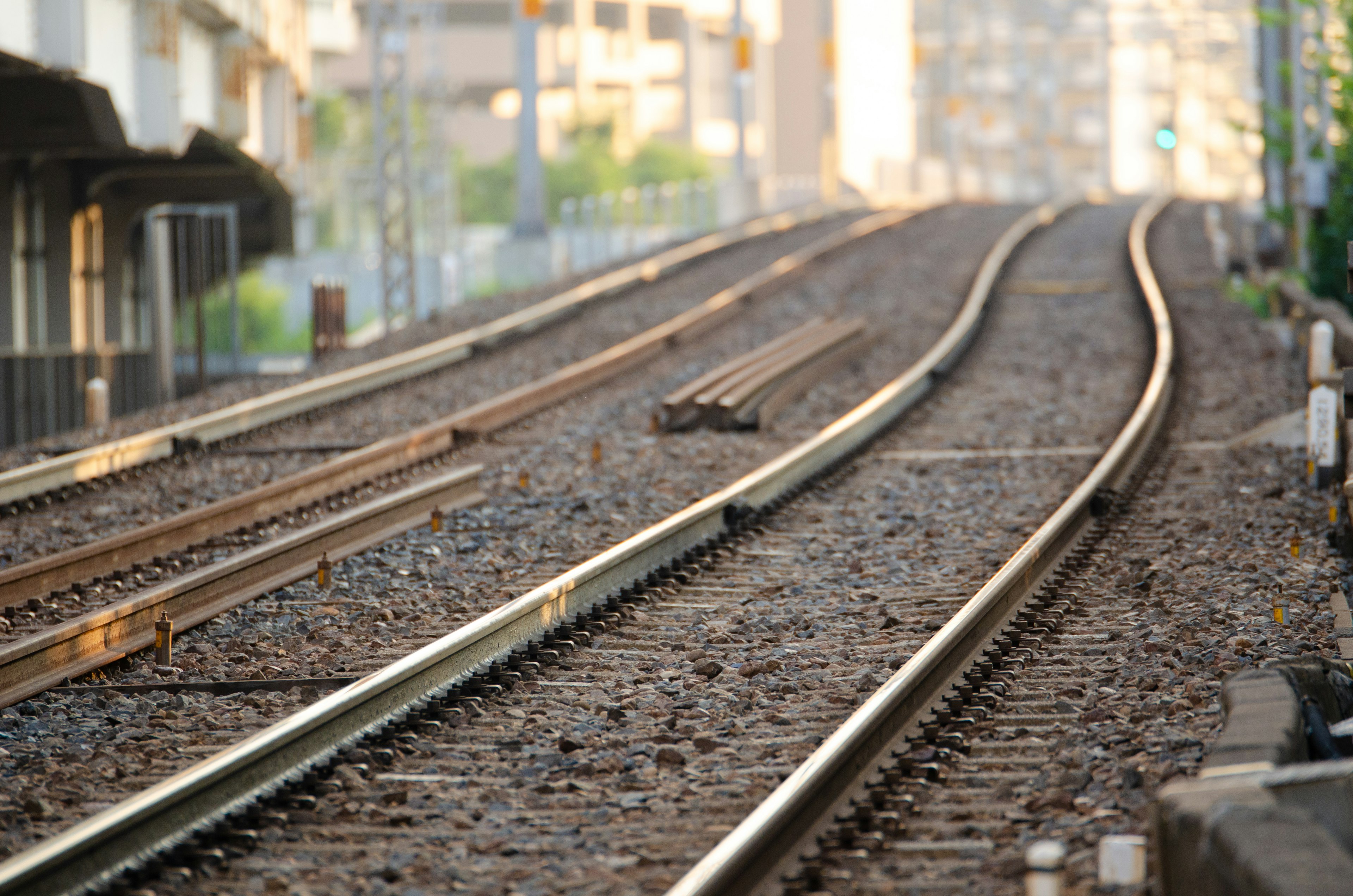 Curved railway tracks with gravel and surrounding urban scenery