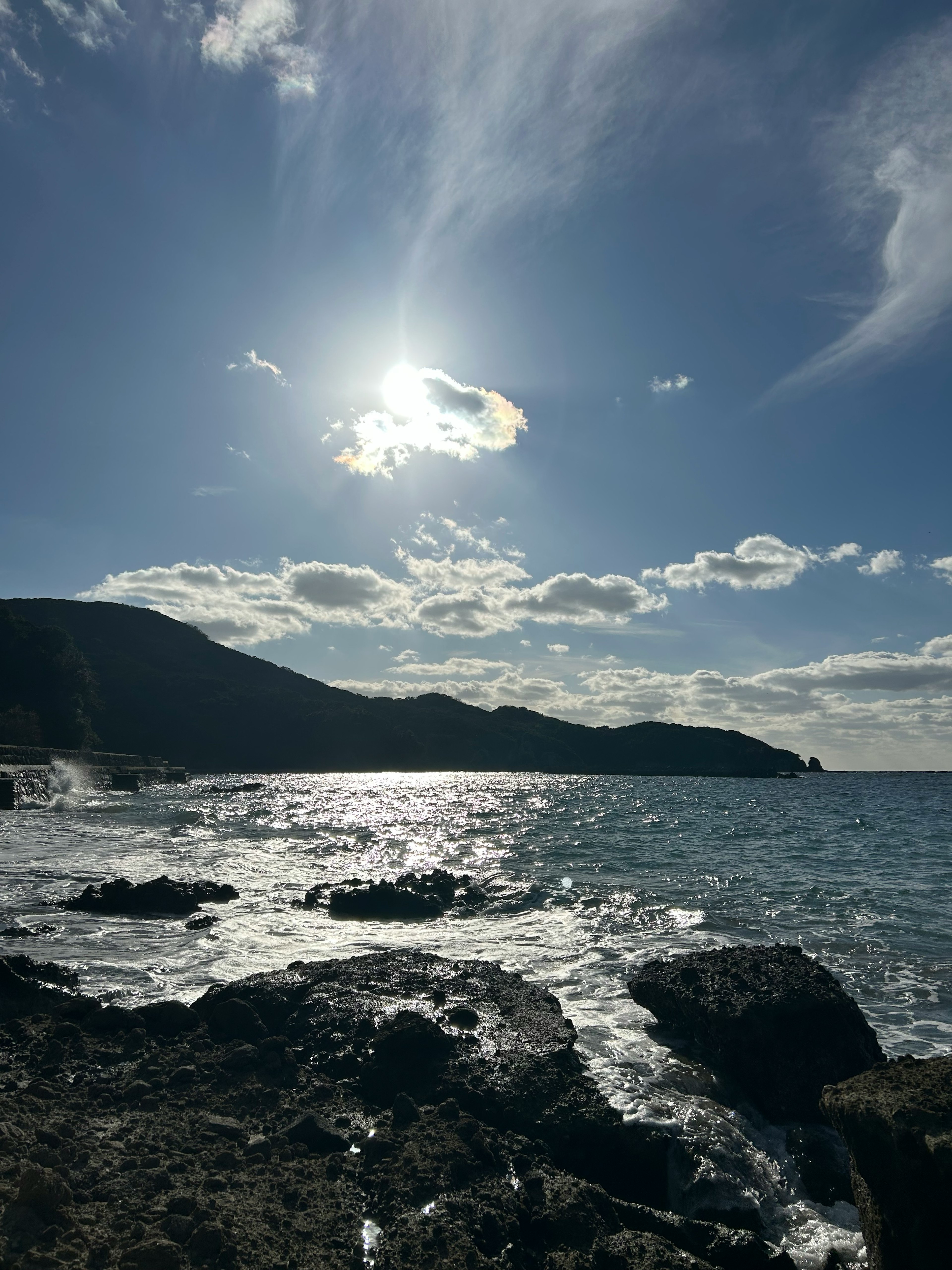 Beautiful coastal view with rocks and sunlight reflecting on the sea