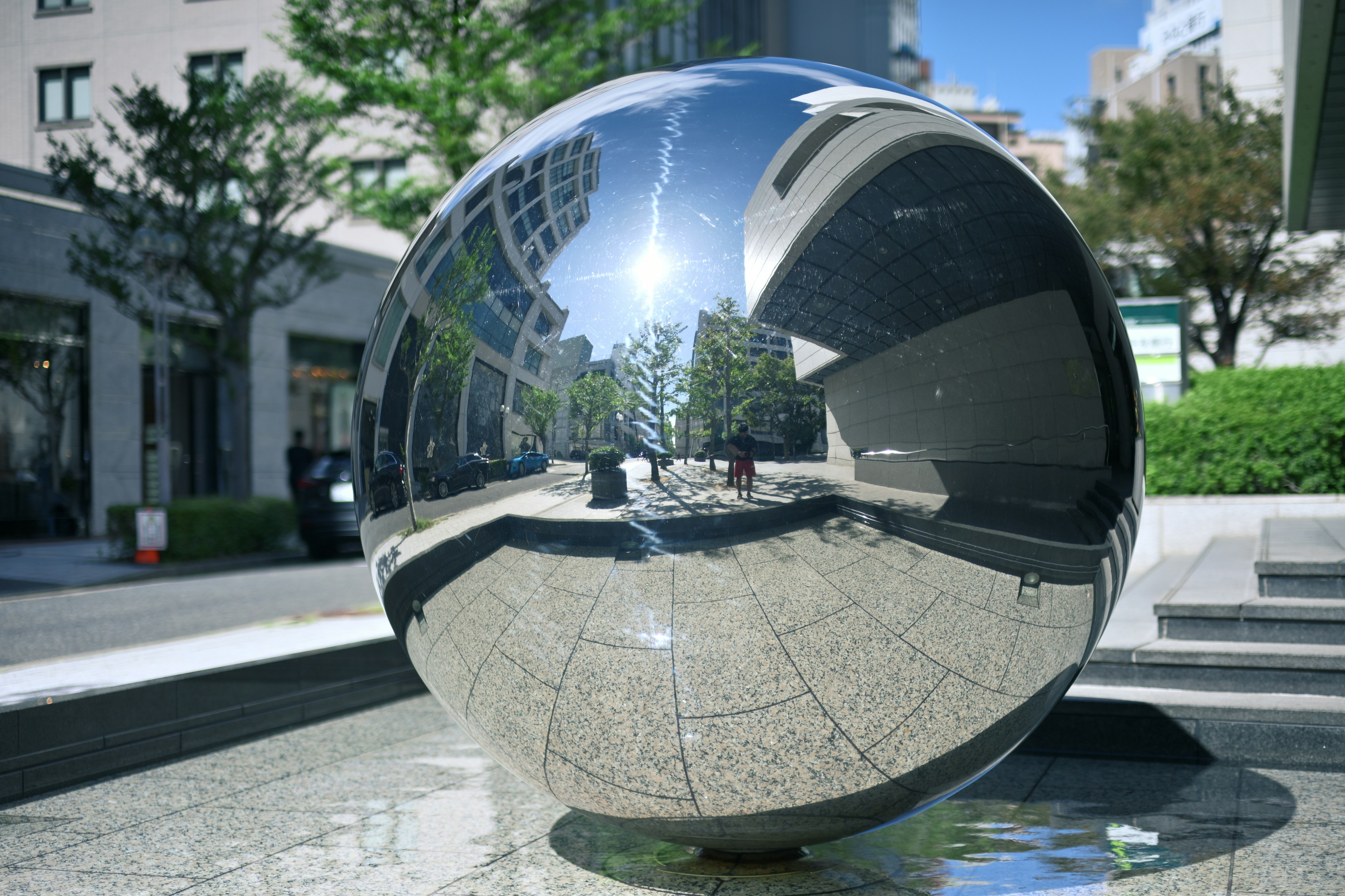 Una scultura sferica riflettente che mostra il paesaggio circostante