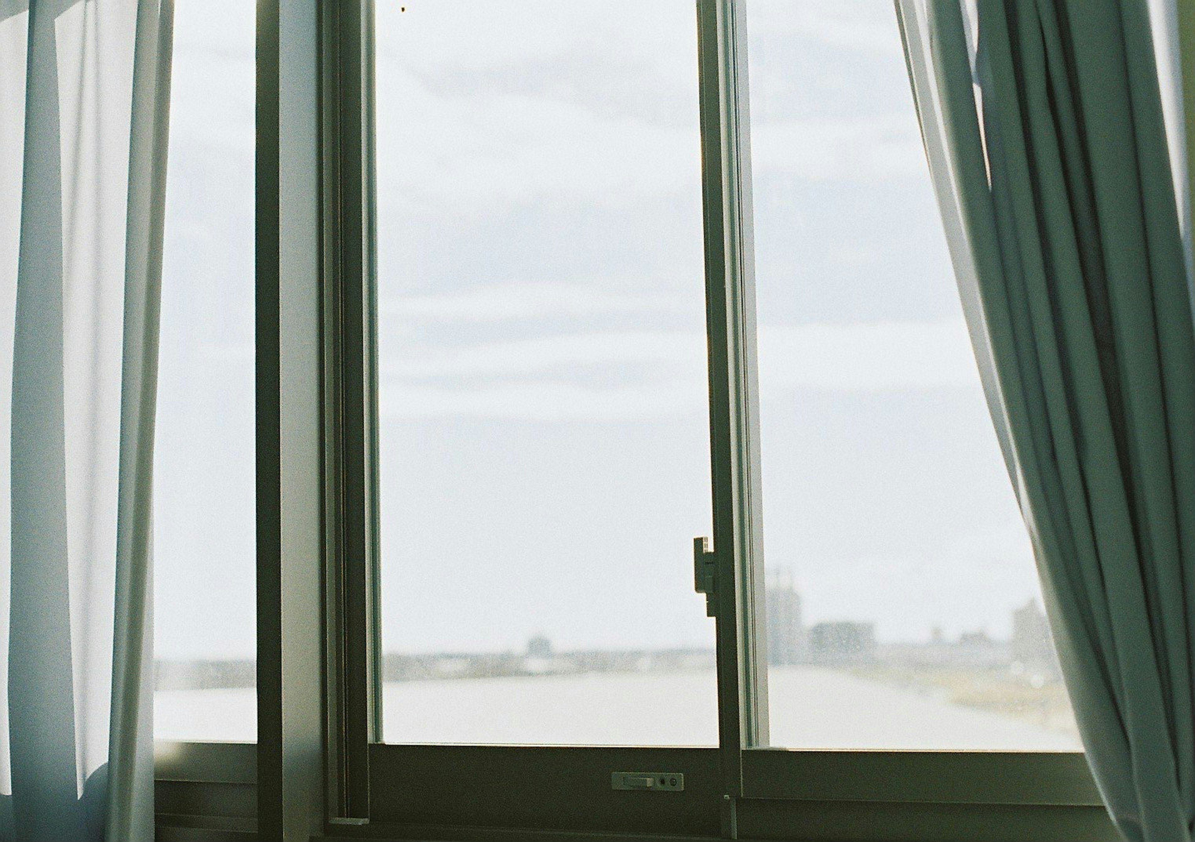 View through a window with curtains and distant scenery