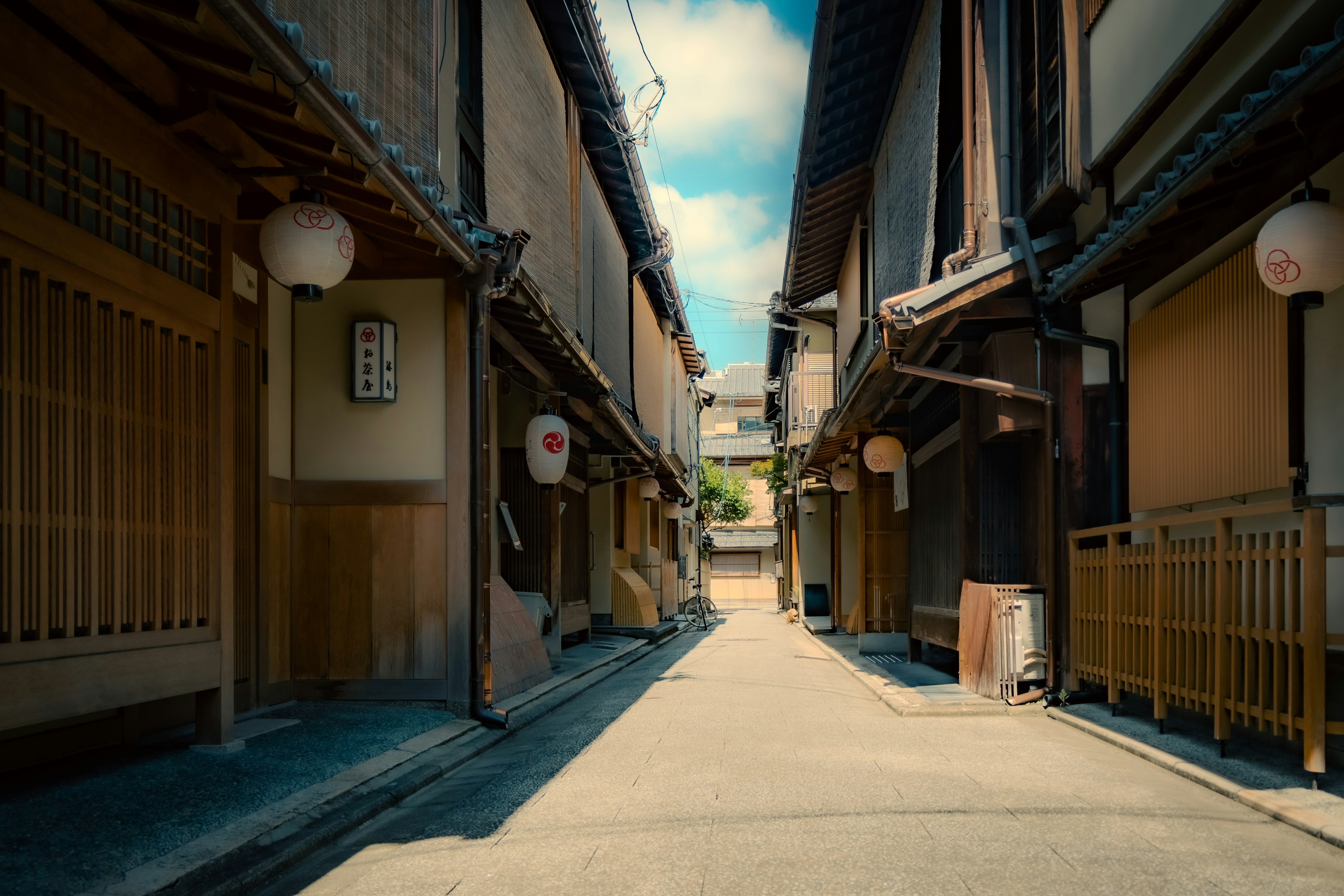 Vicolo stretto a Kyoto con edifici in legno tradizionali e lanterne