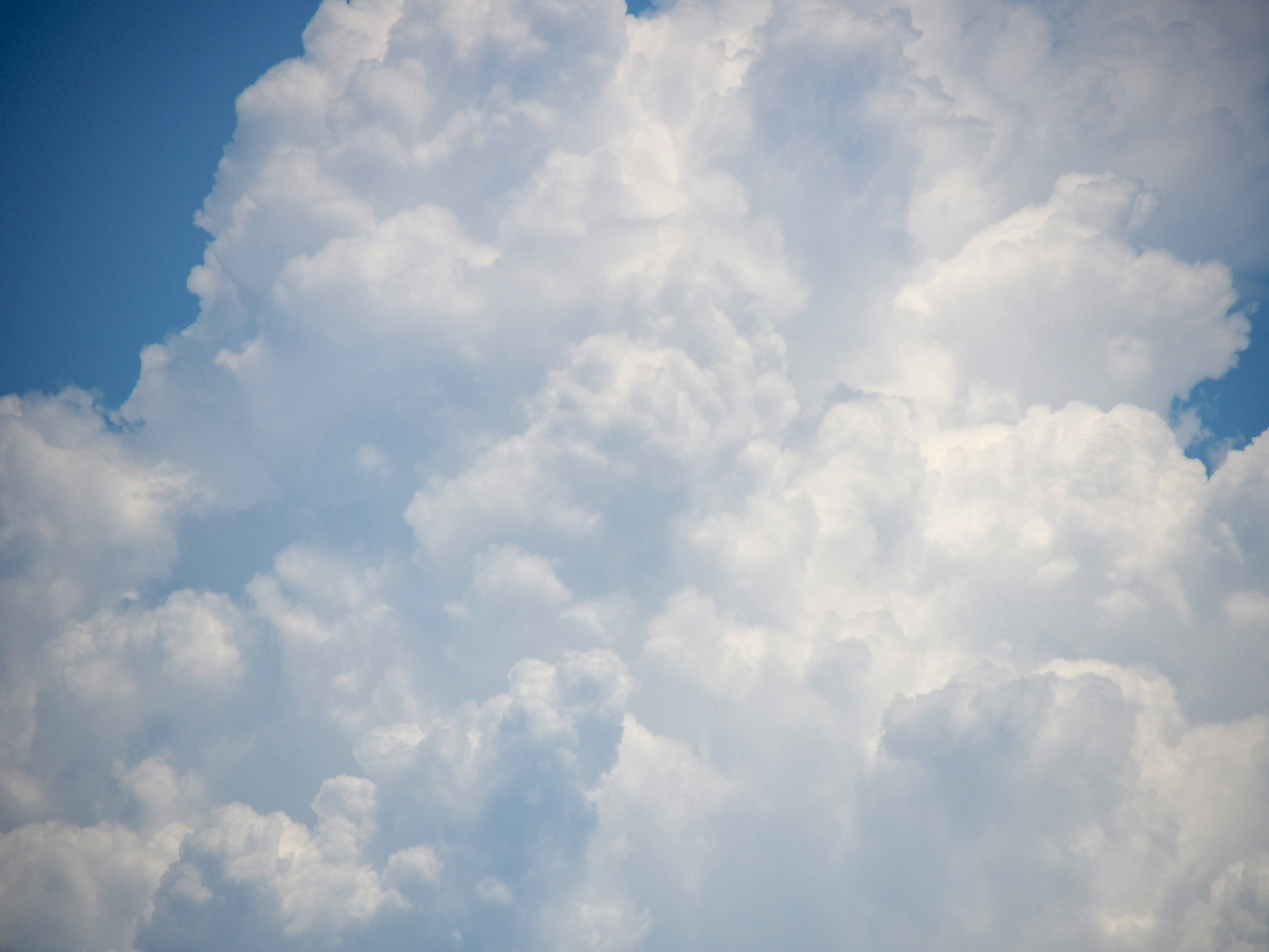 Fluffige weiße Wolken vor blauem Himmel