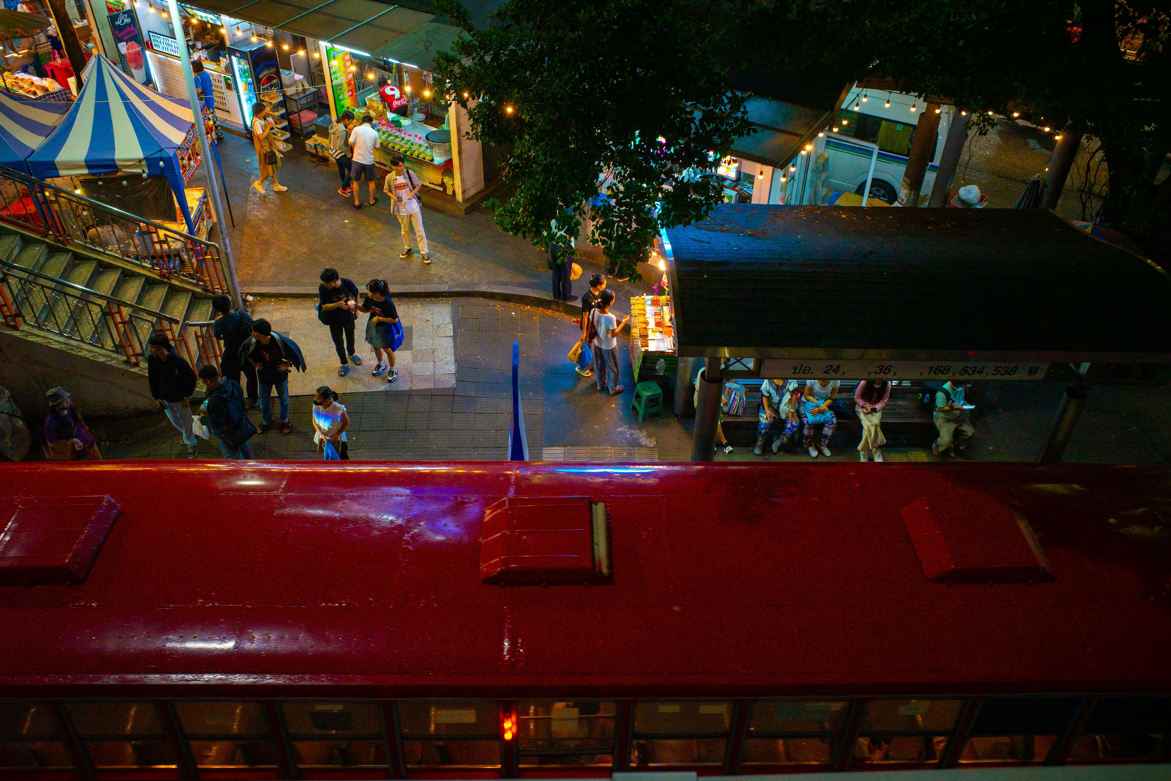 Una scena vivace con un treno rosso e bancarelle di mercato notturno