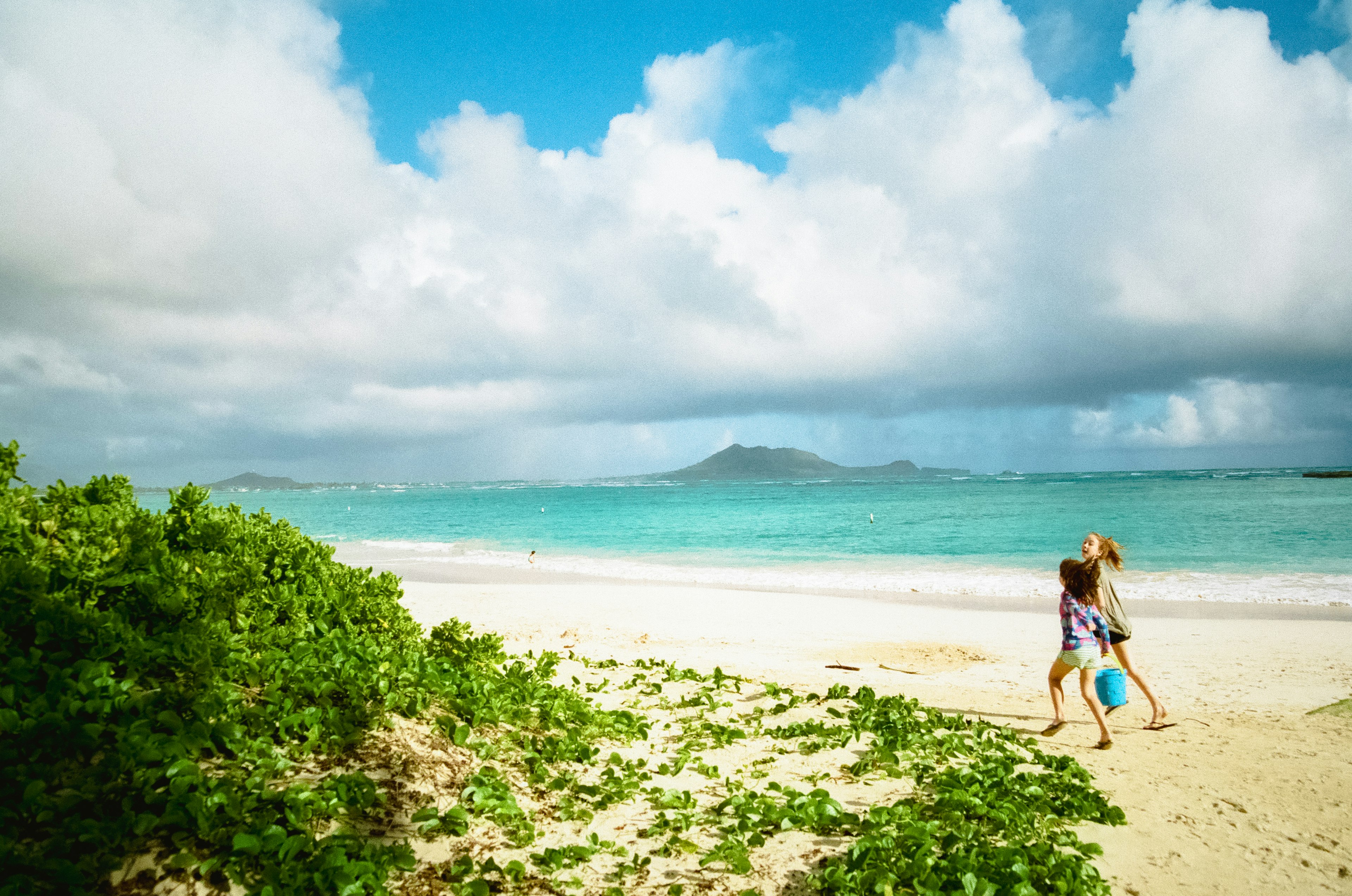 Children playing on the beach with blue sea and sky