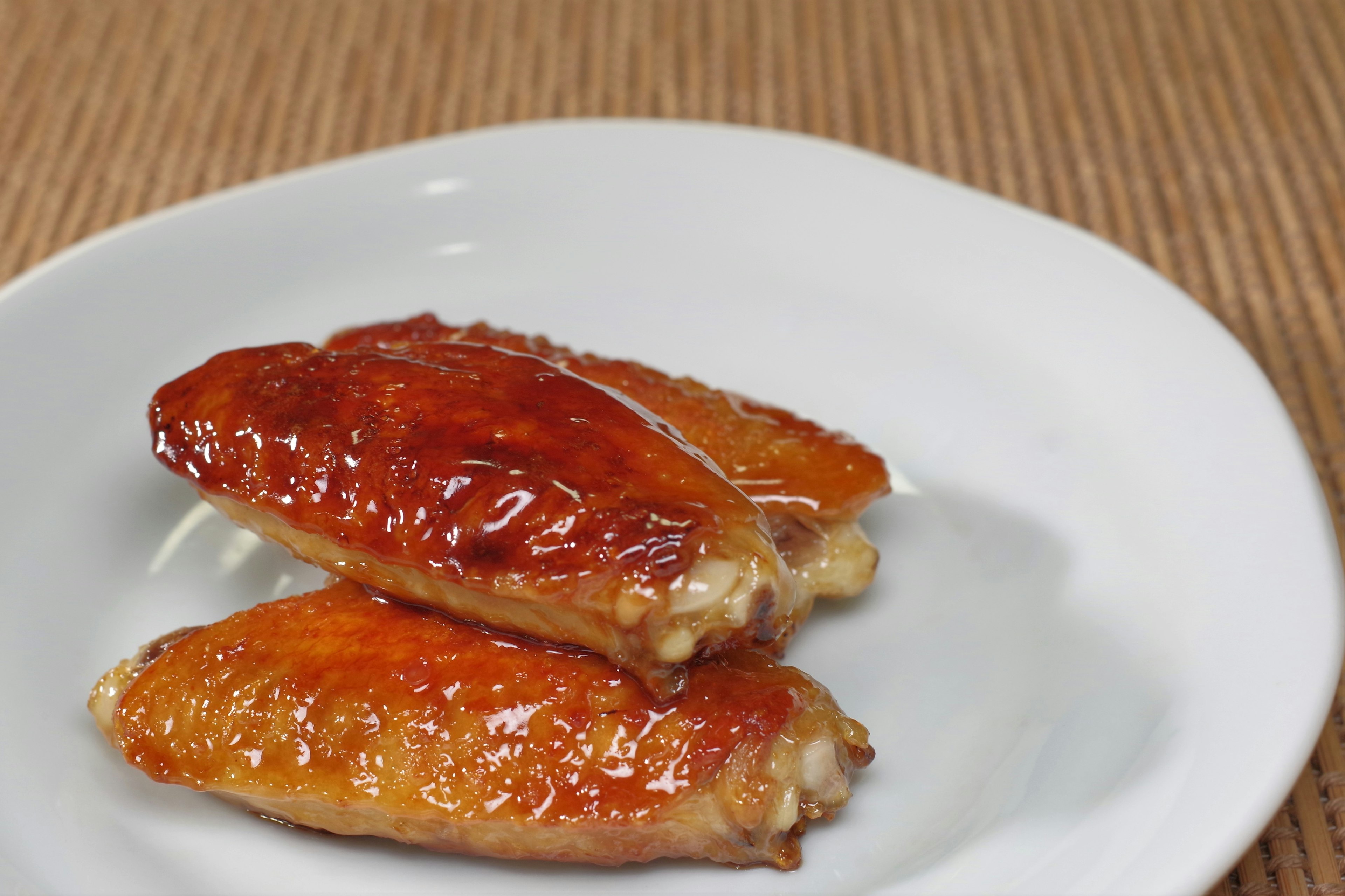 Glazed chicken wings on a white plate