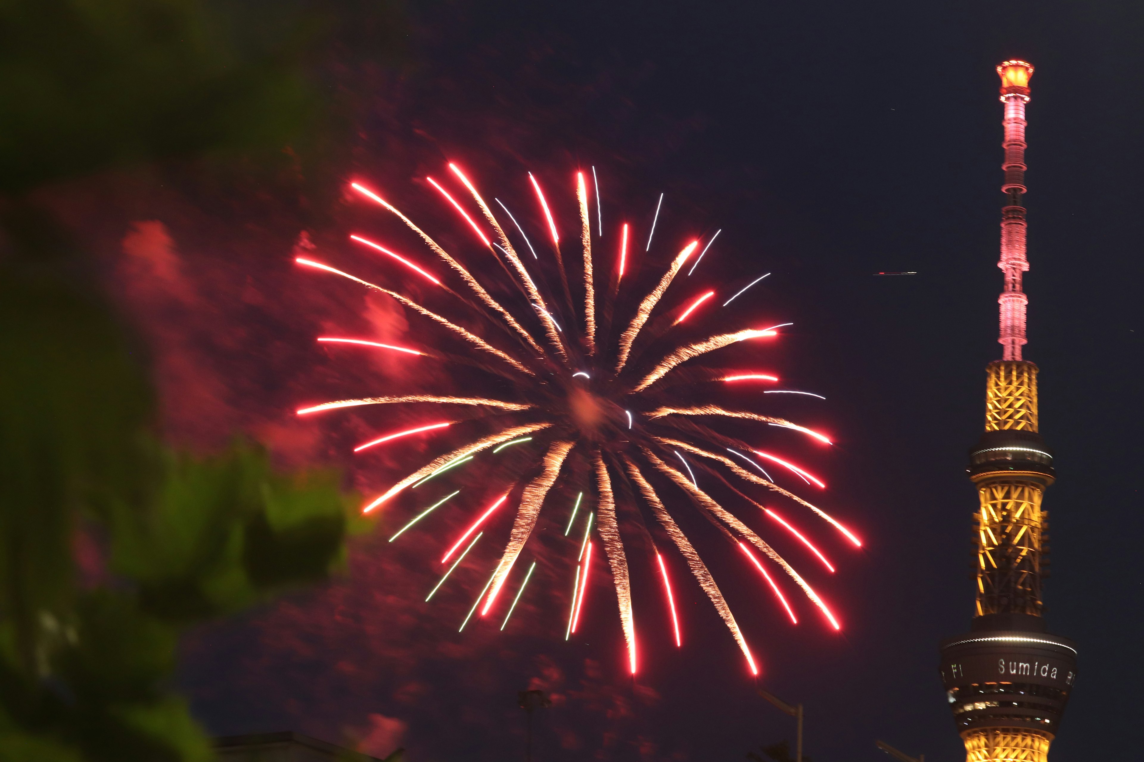 Hermoso momento de fuegos artificiales rojos lanzados cerca de la Torre de Tokio