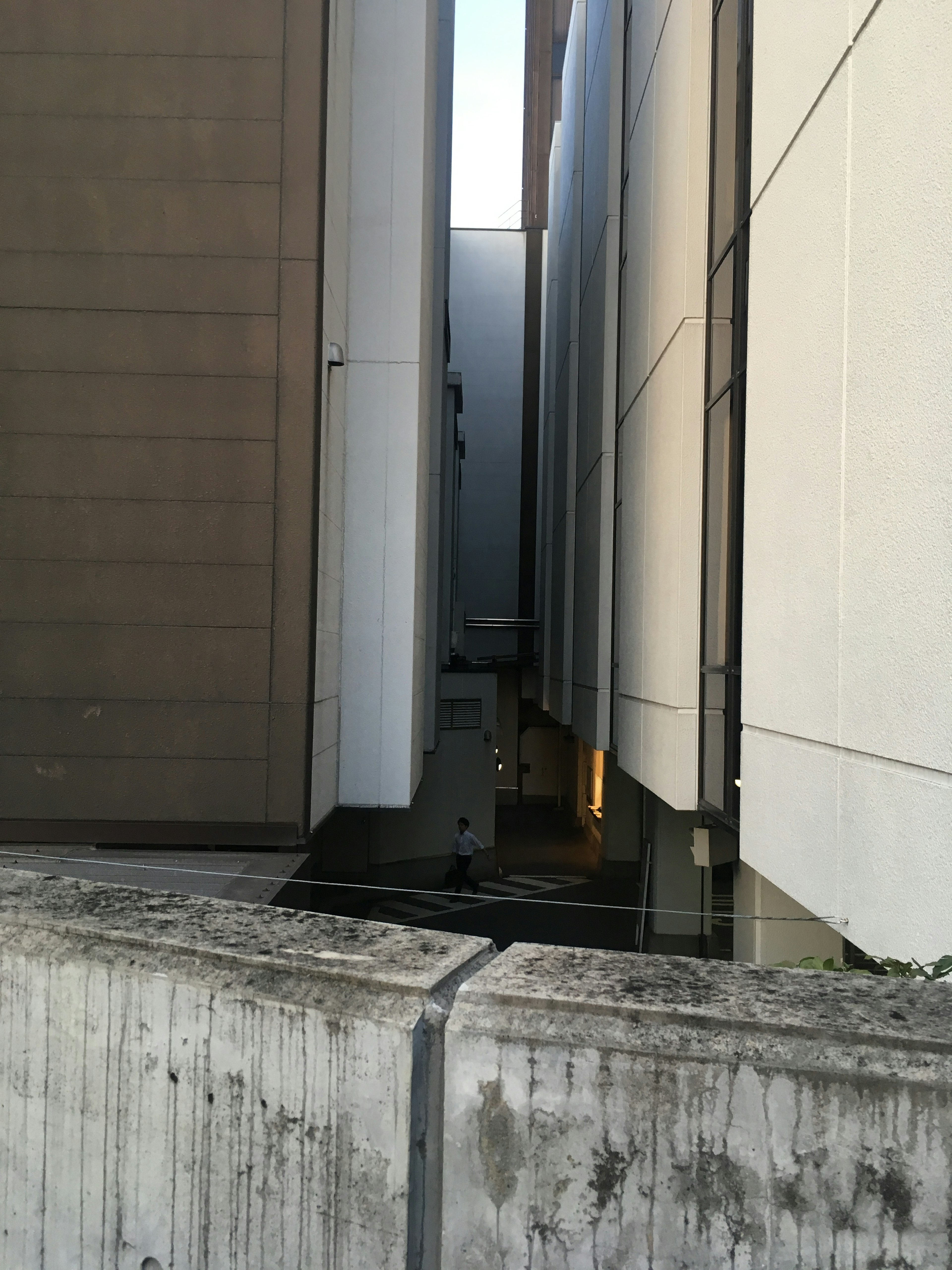 Narrow gap between modern buildings showcasing concrete and white walls