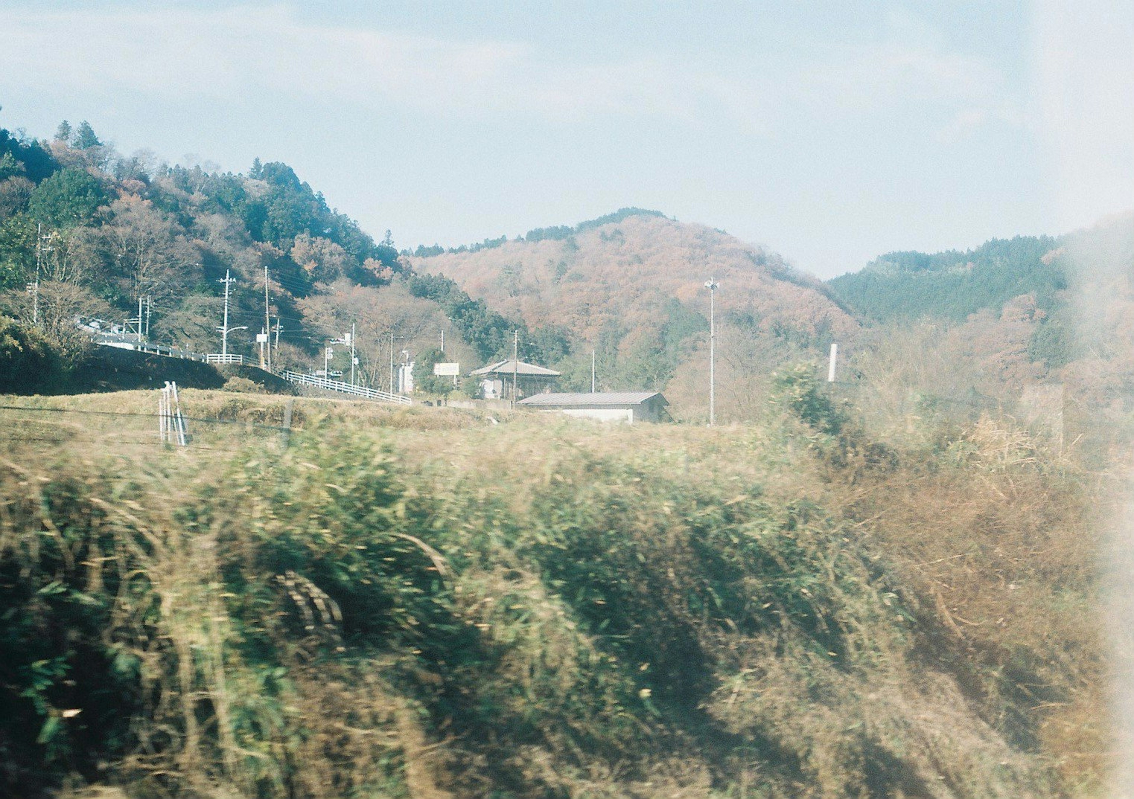 Scenic view of mountains and grassy fields under a blue sky