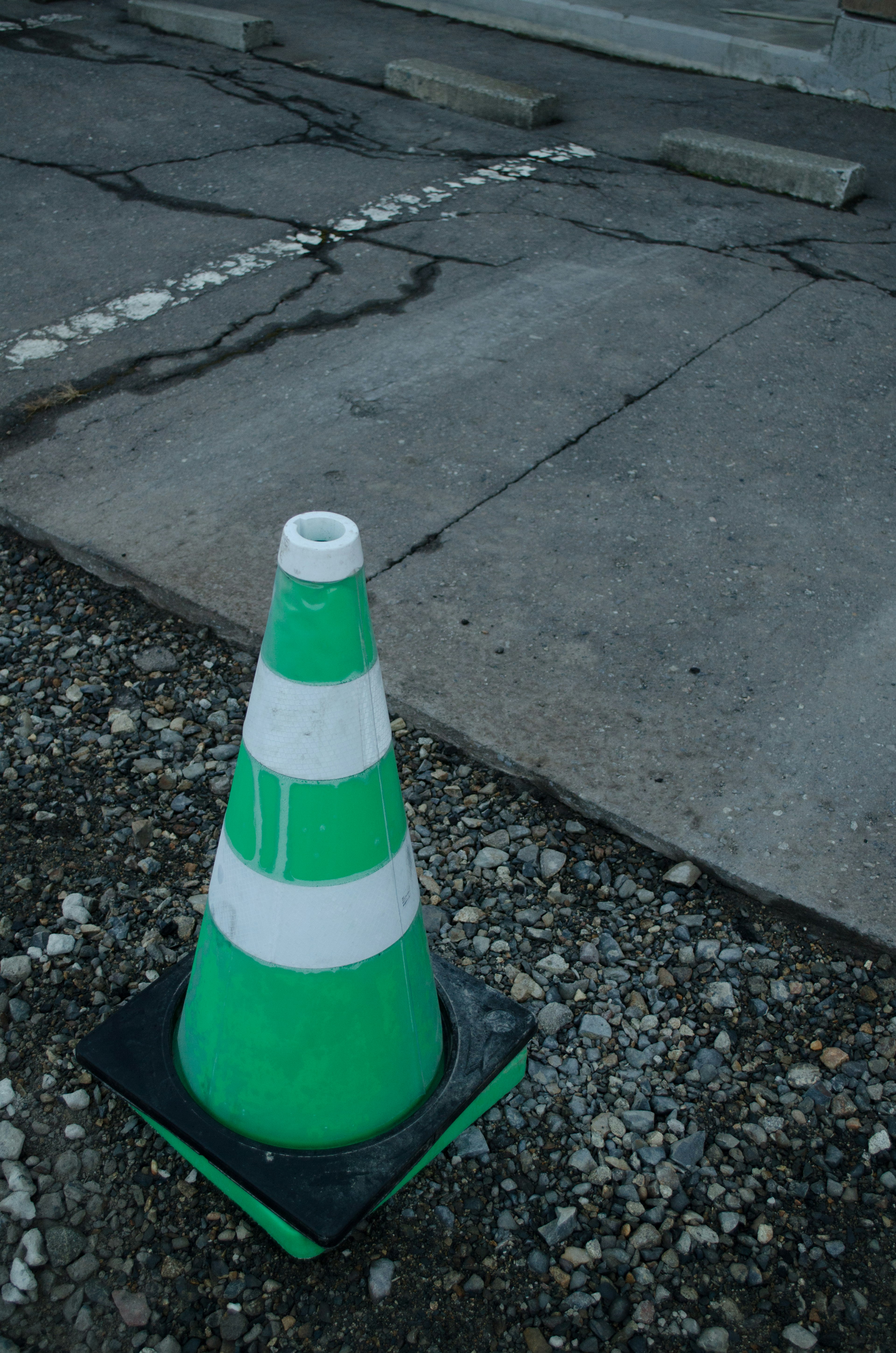 Green and white traffic cone placed on the ground