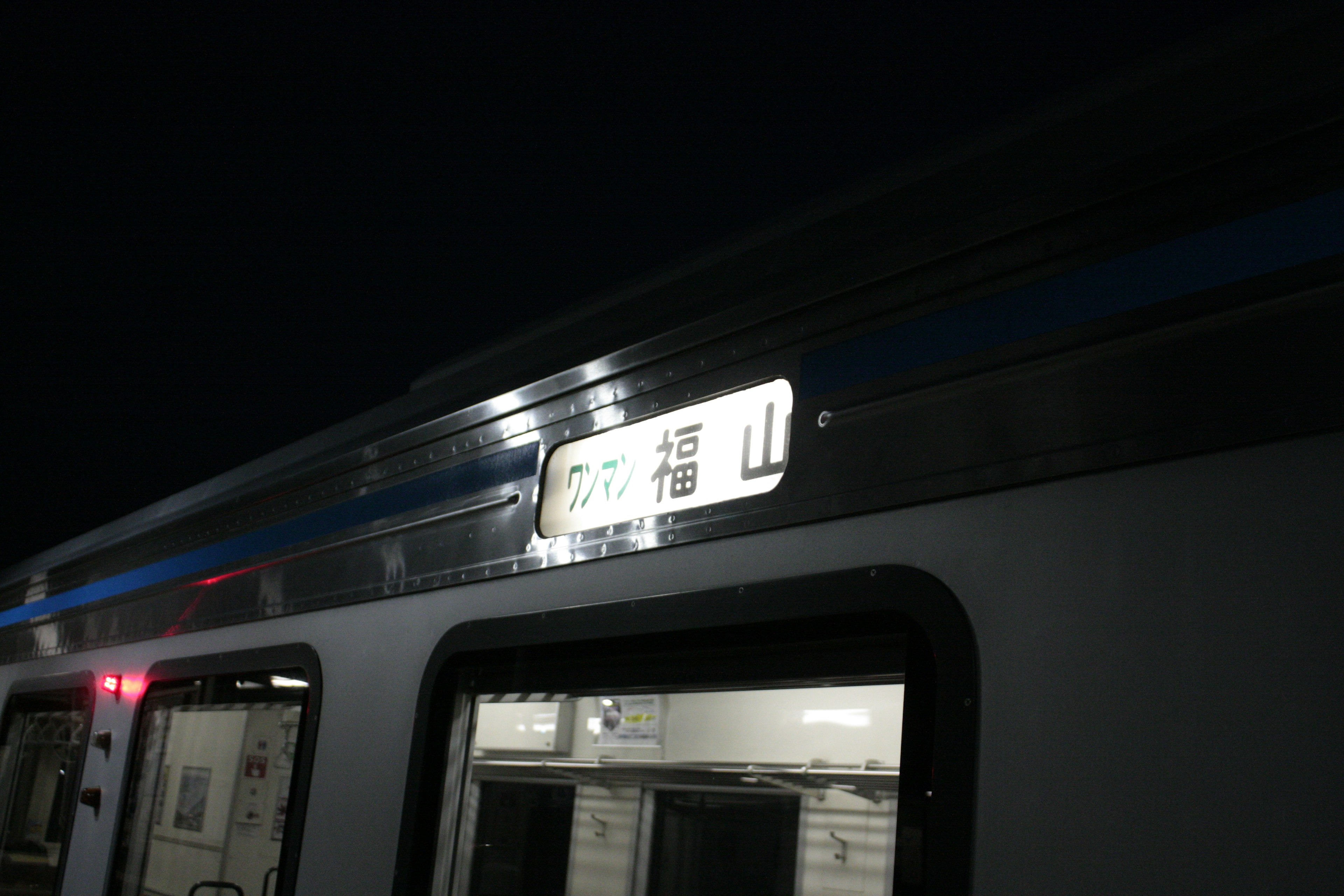 Vista lateral de un tren nocturno con letrero de destino