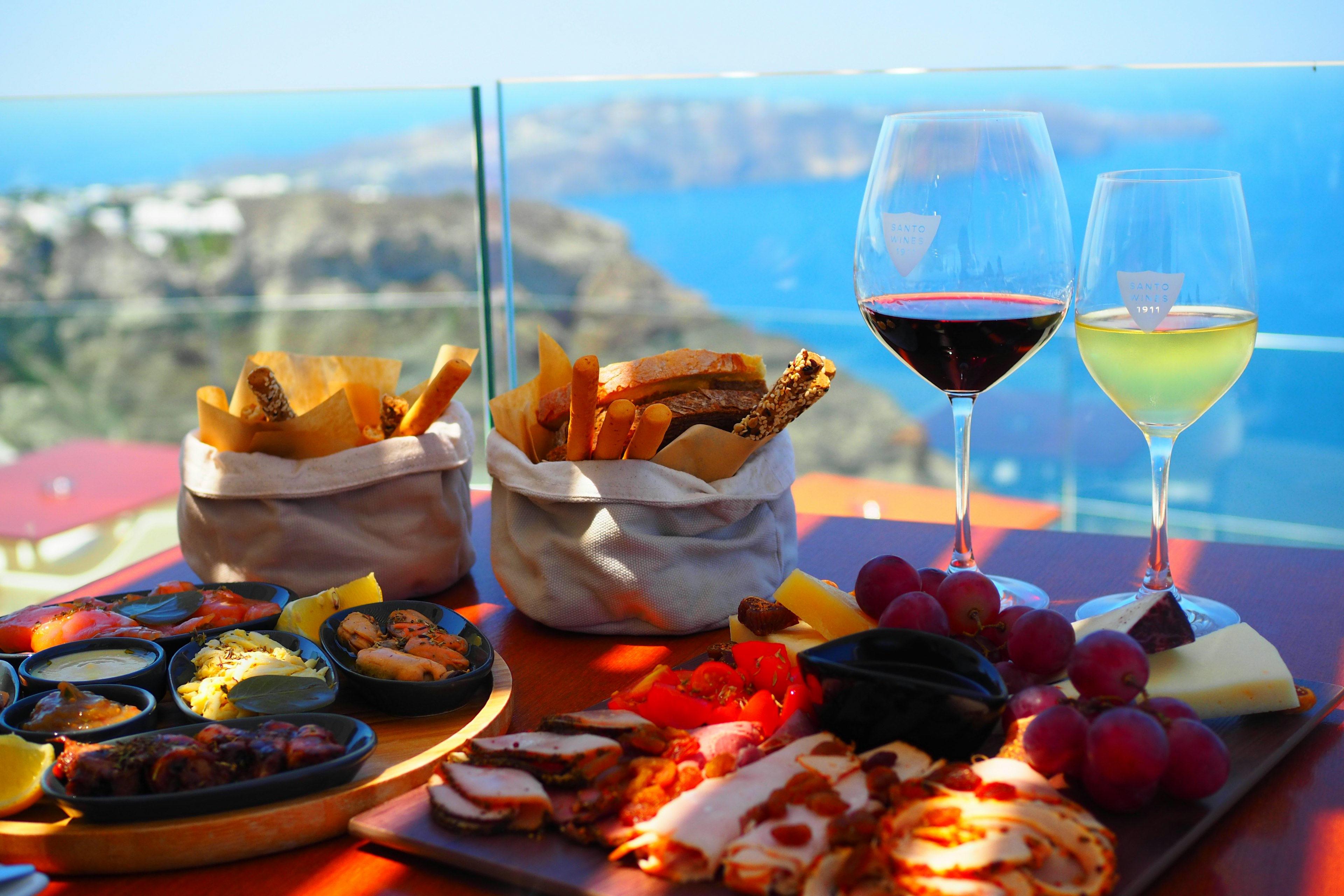 Dining table with a stunning ocean view featuring gourmet dishes and wine glasses