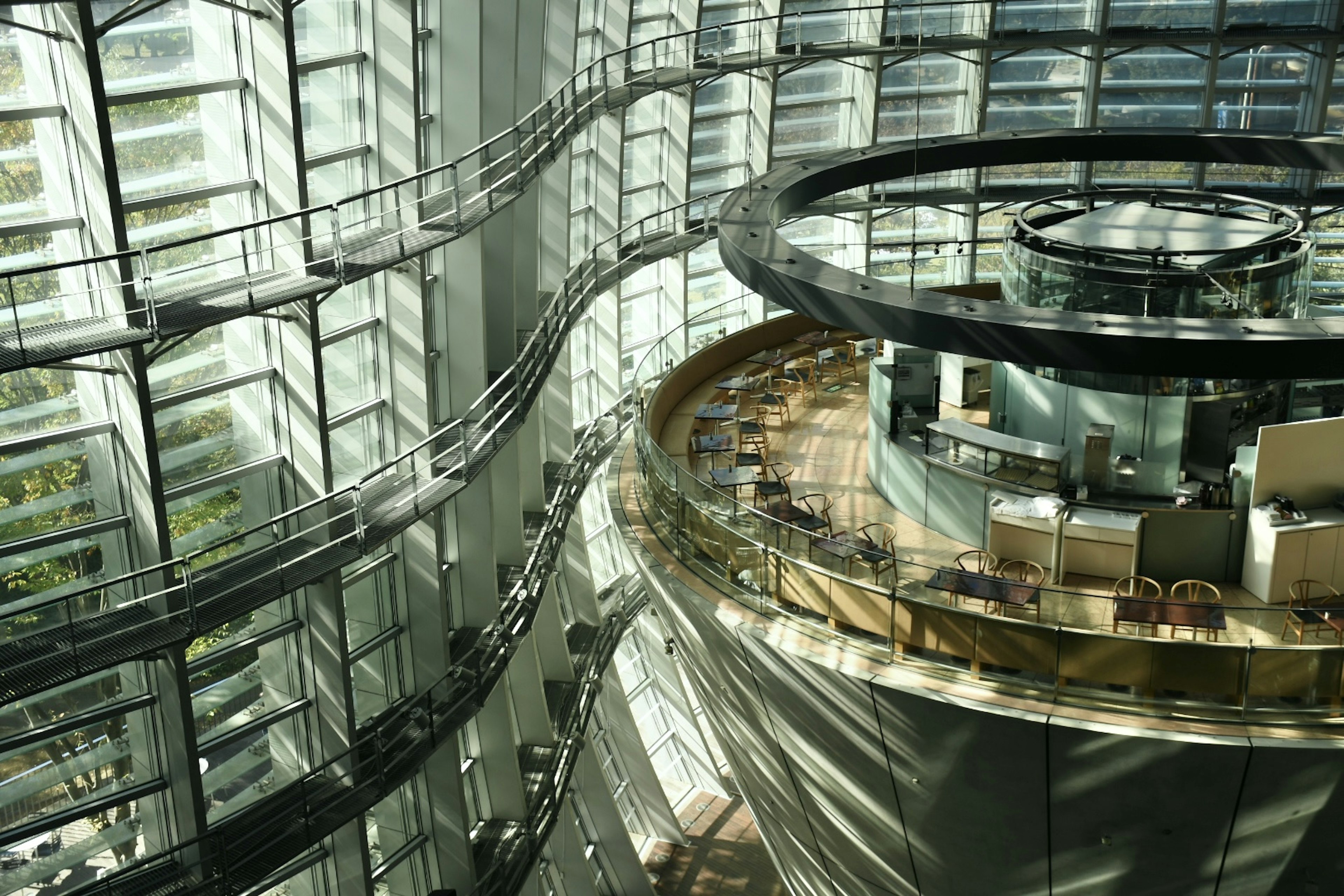 Interior de un edificio de oficinas moderno con paredes de vidrio brillantes y escaleras curvas