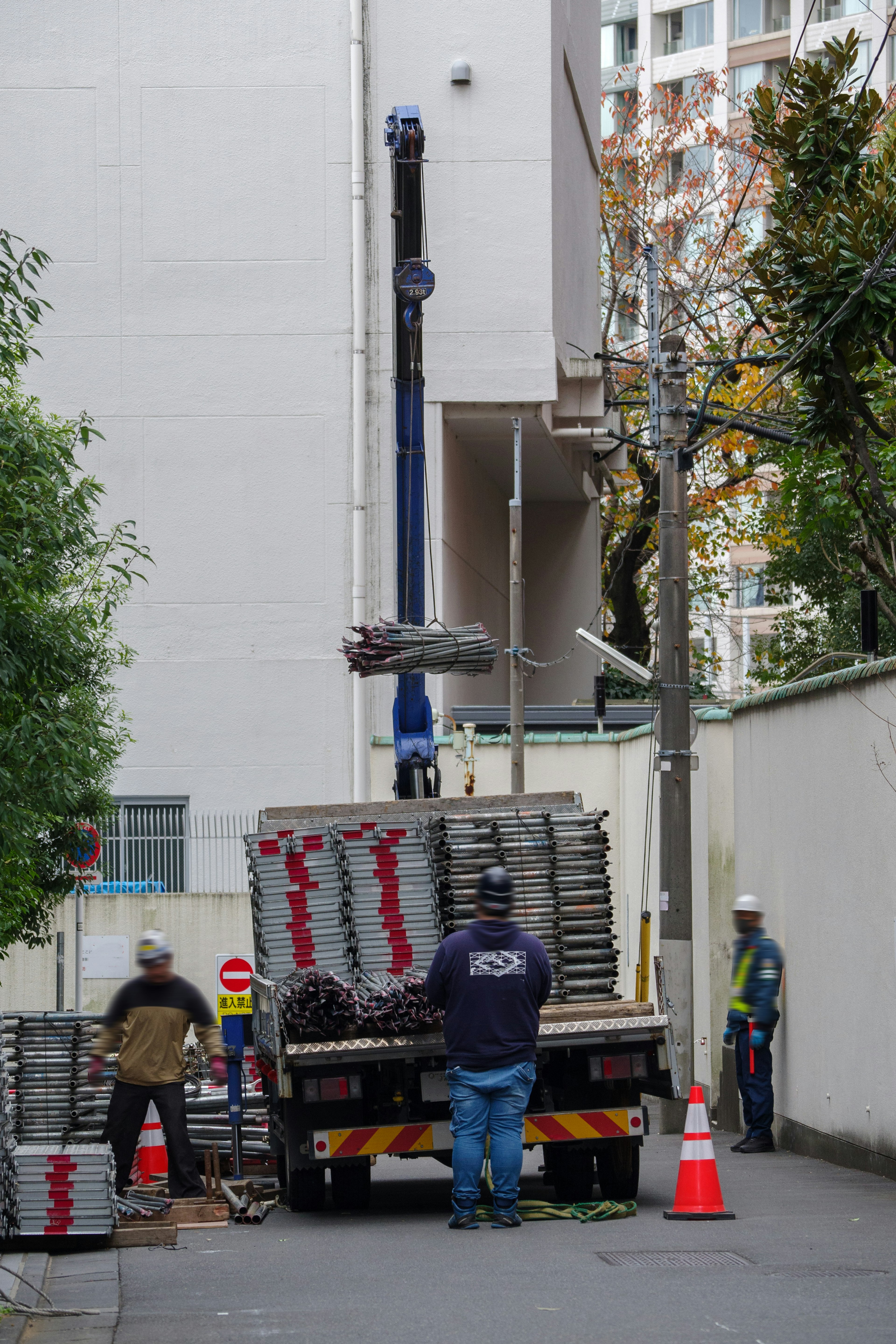 Workers unloading materials from a truck in an alley