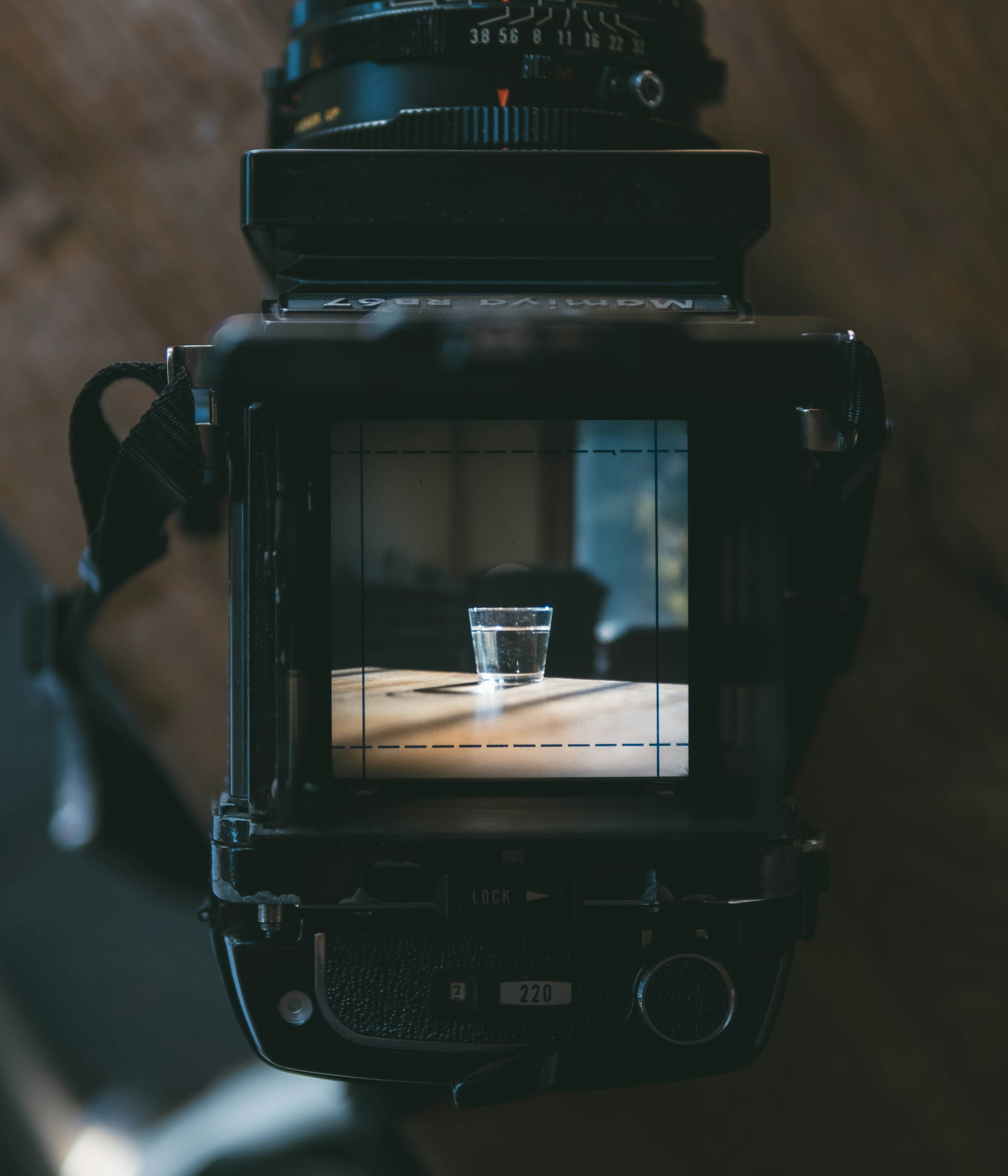 View from above a camera showing a glass of water on a wooden table