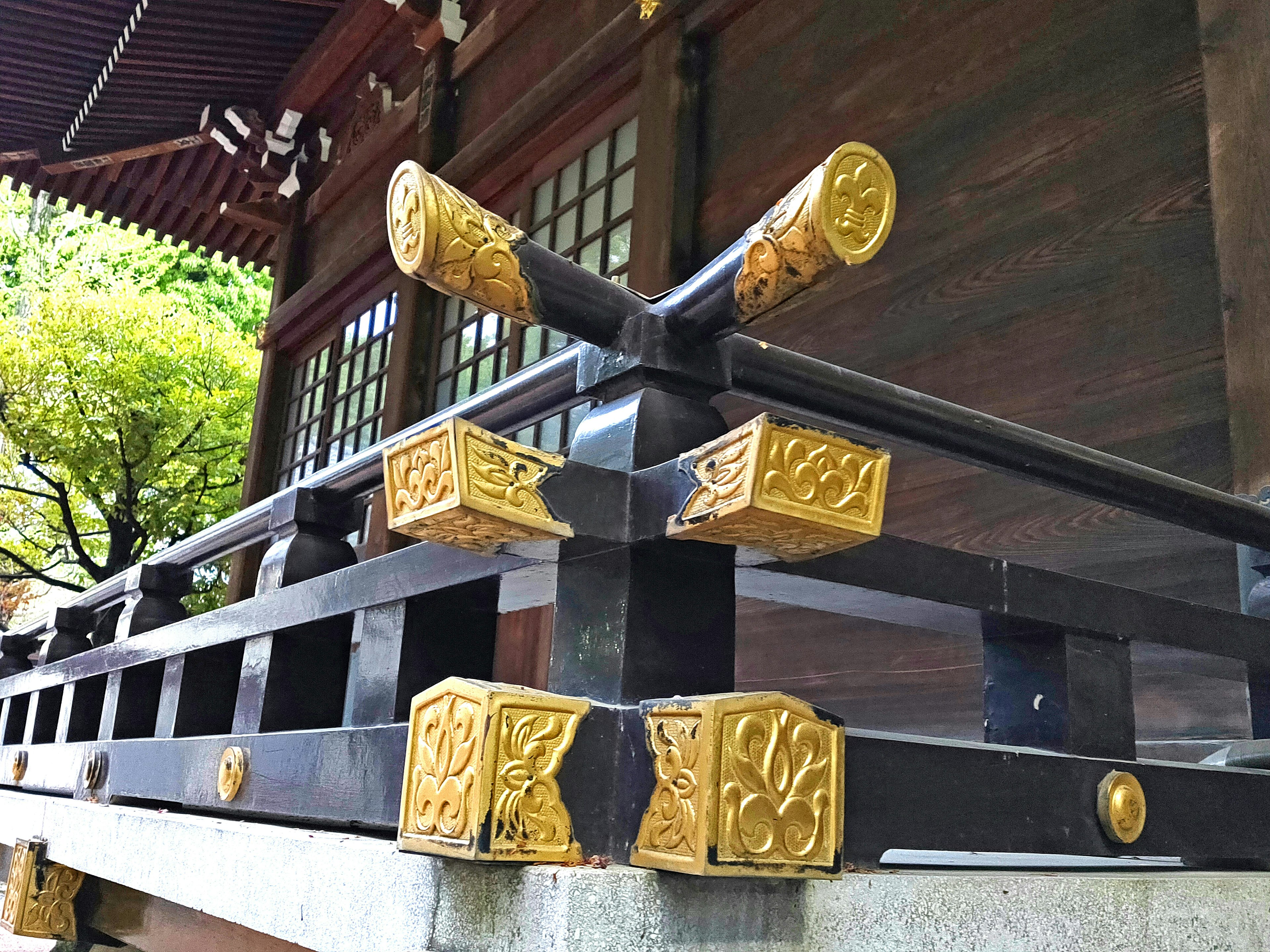 Close-up of a black railing with beautiful golden decorations