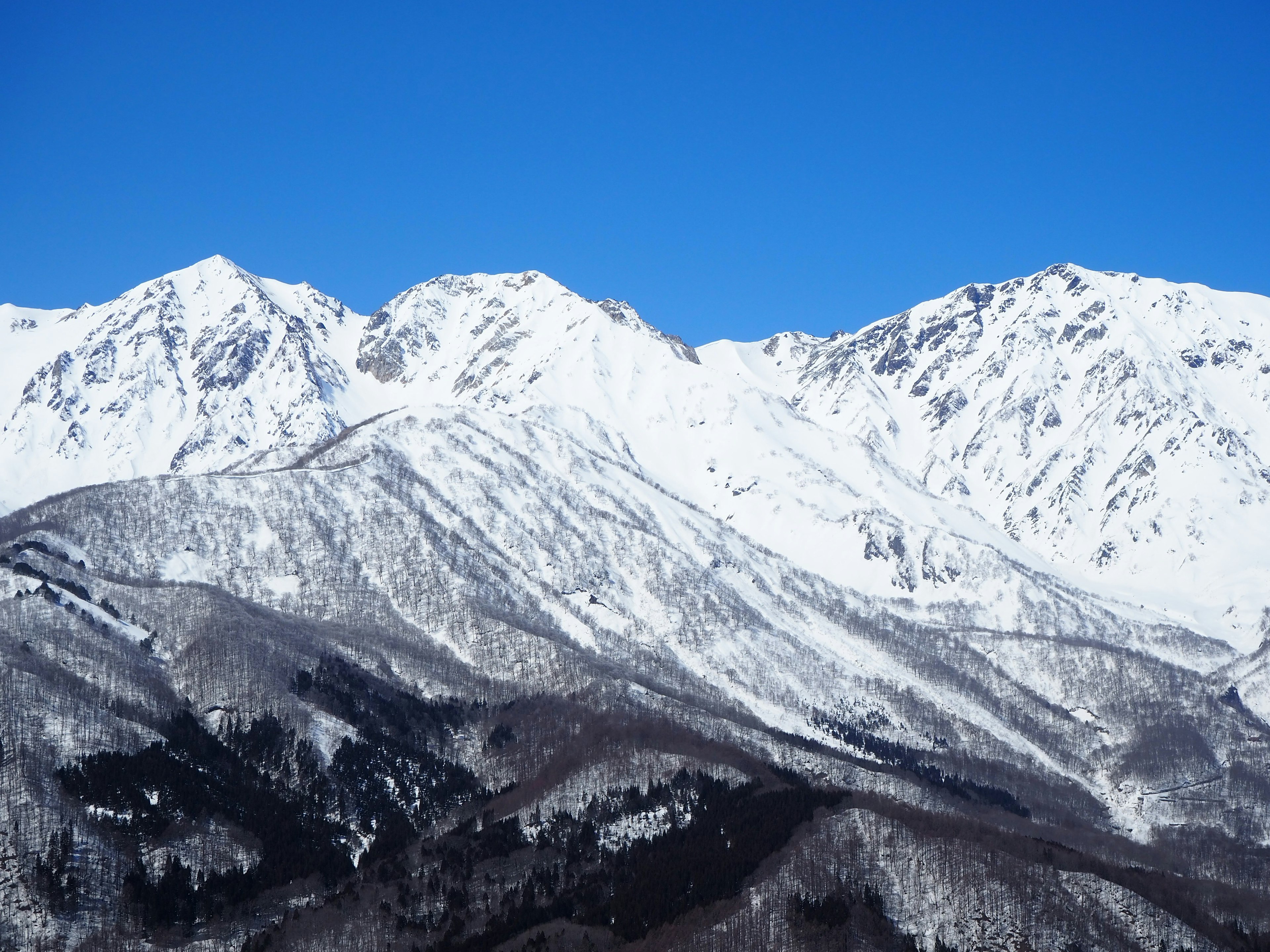 Snow-covered mountains under a clear blue sky