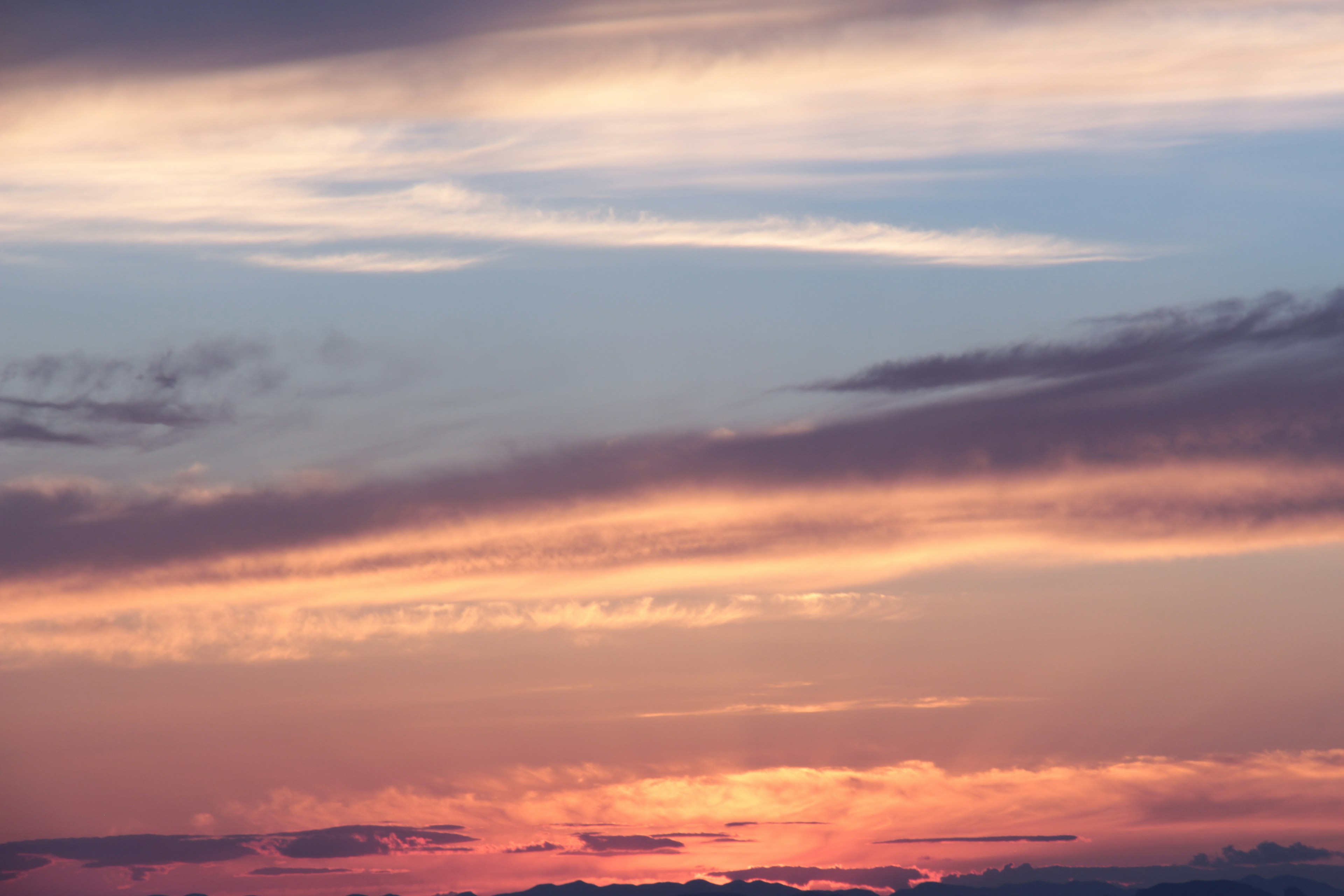 夕日の美しい色合いと雲のパターンが広がる空