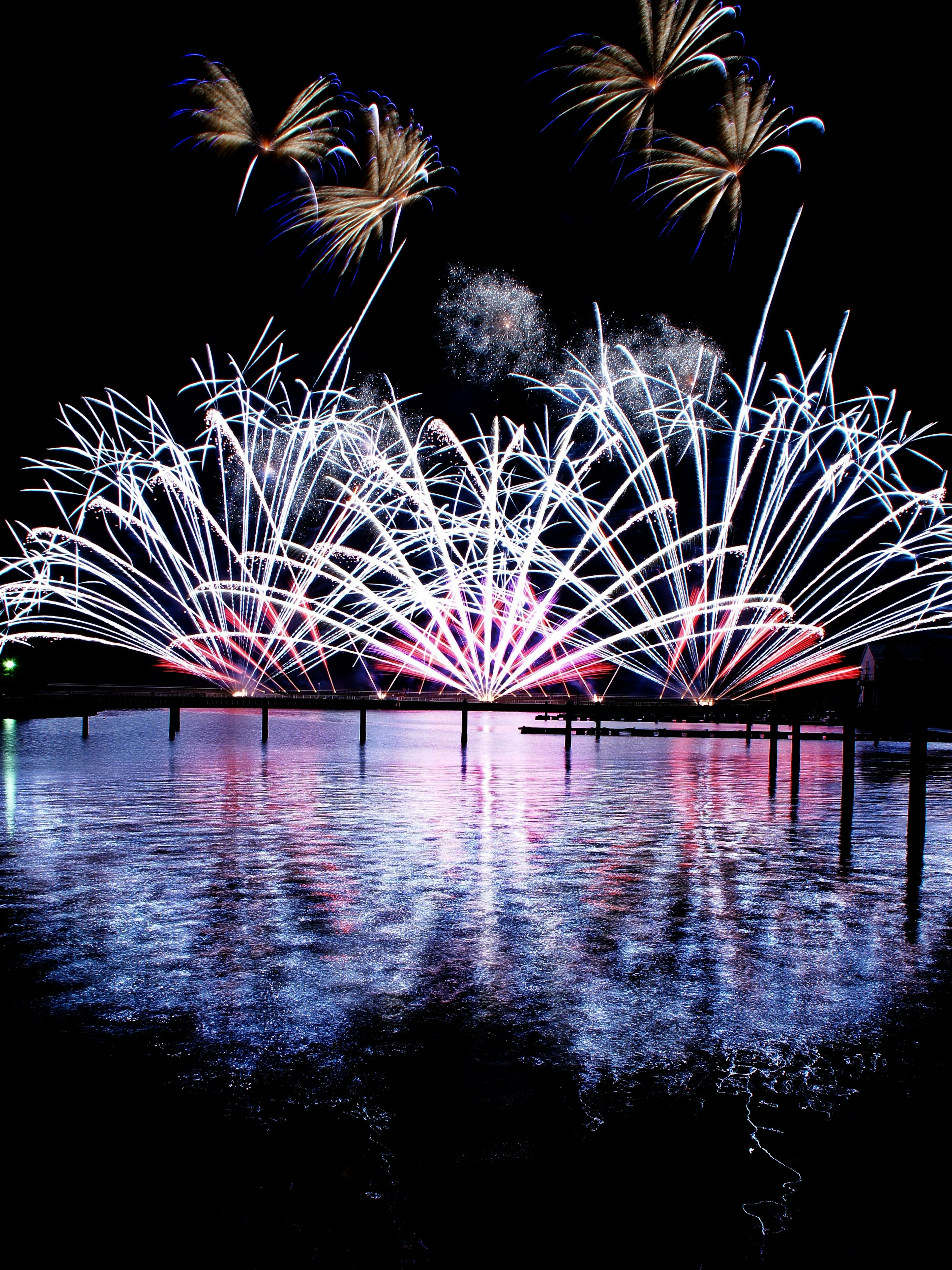 Una bellissima scena di fuochi d'artificio che si riflettono sul lago di notte