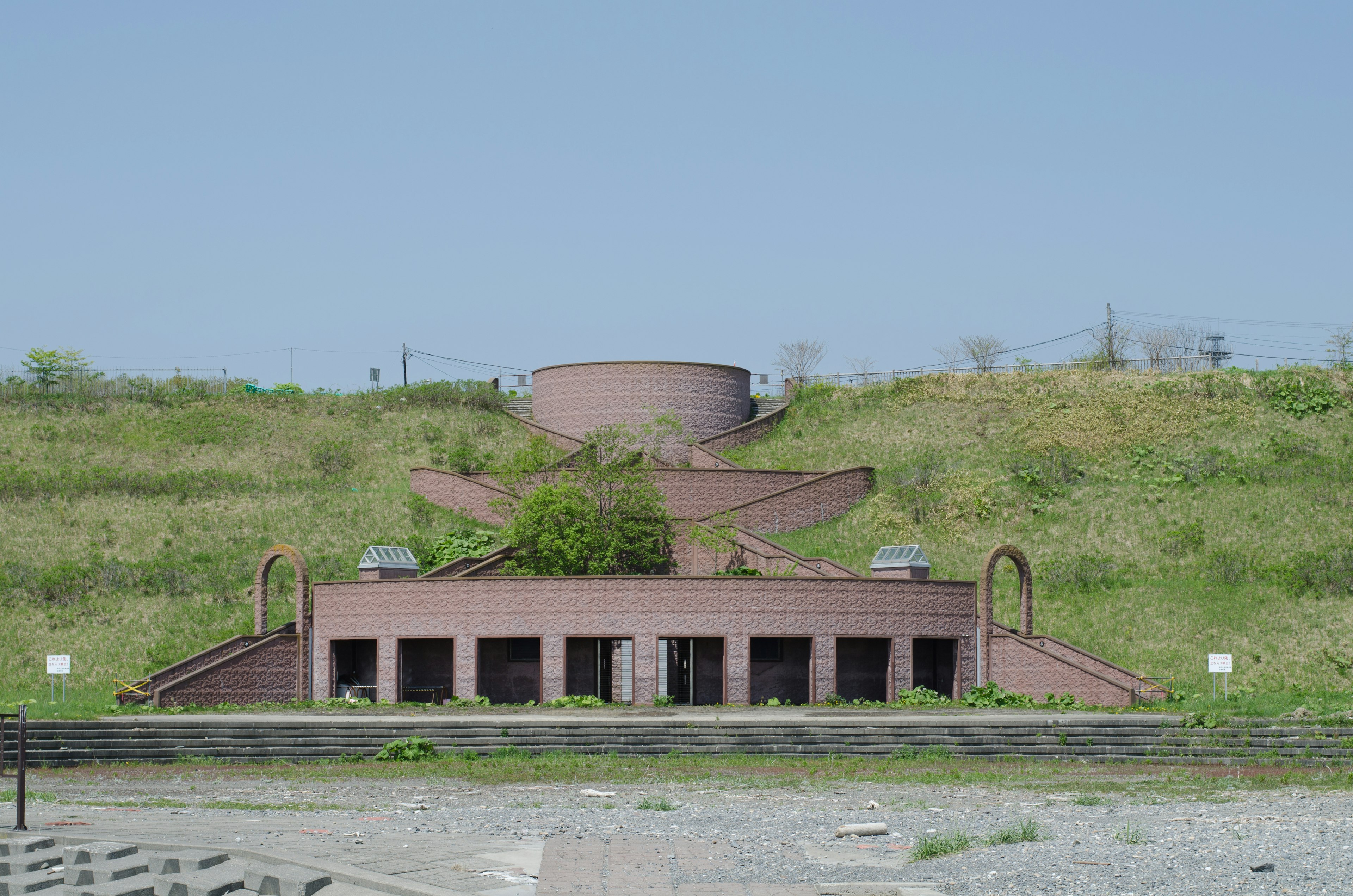 Edificio unico con scale su una collina verdeggiante