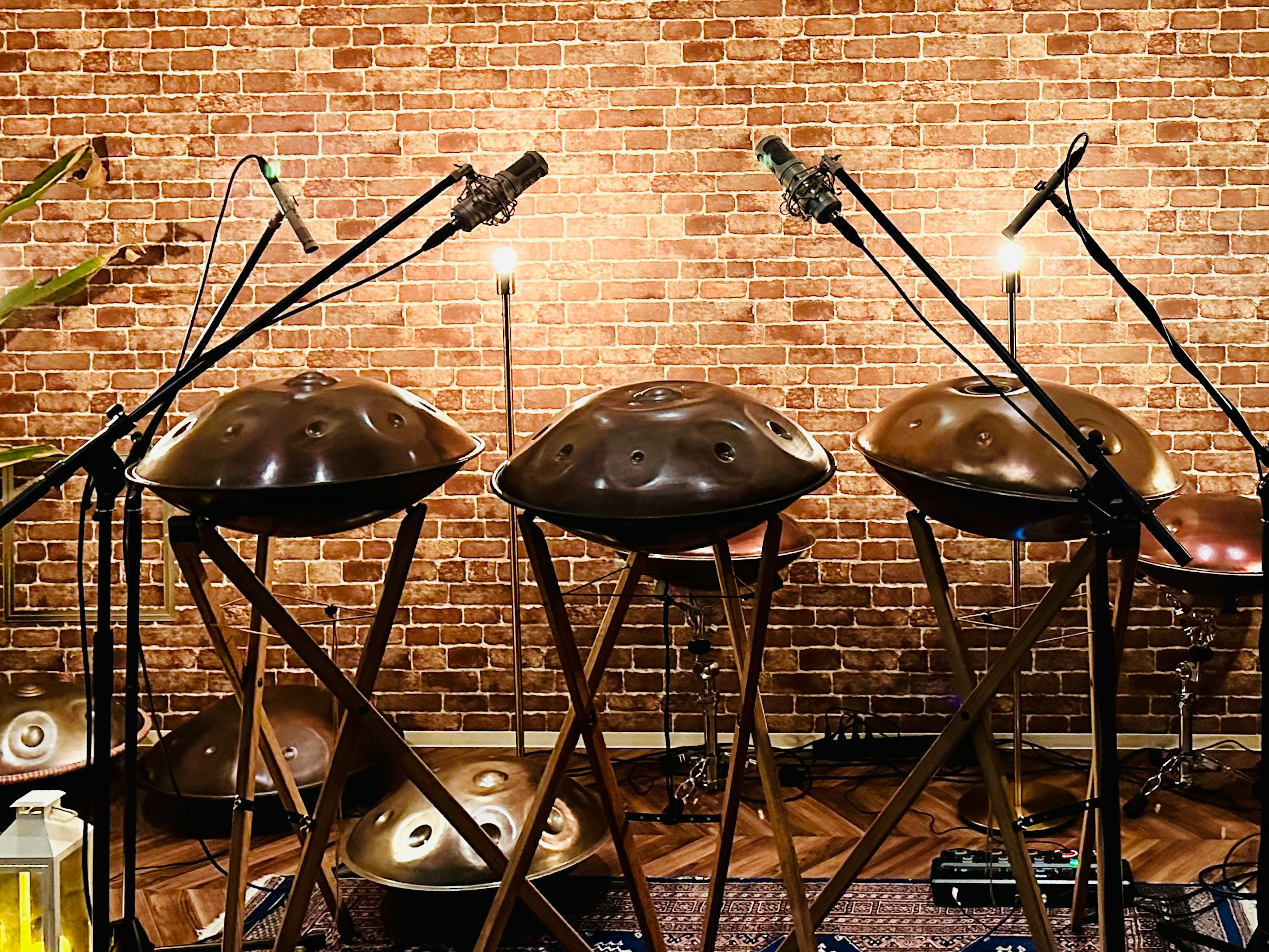 Ensemble de handpans avec des microphones devant un mur en briques