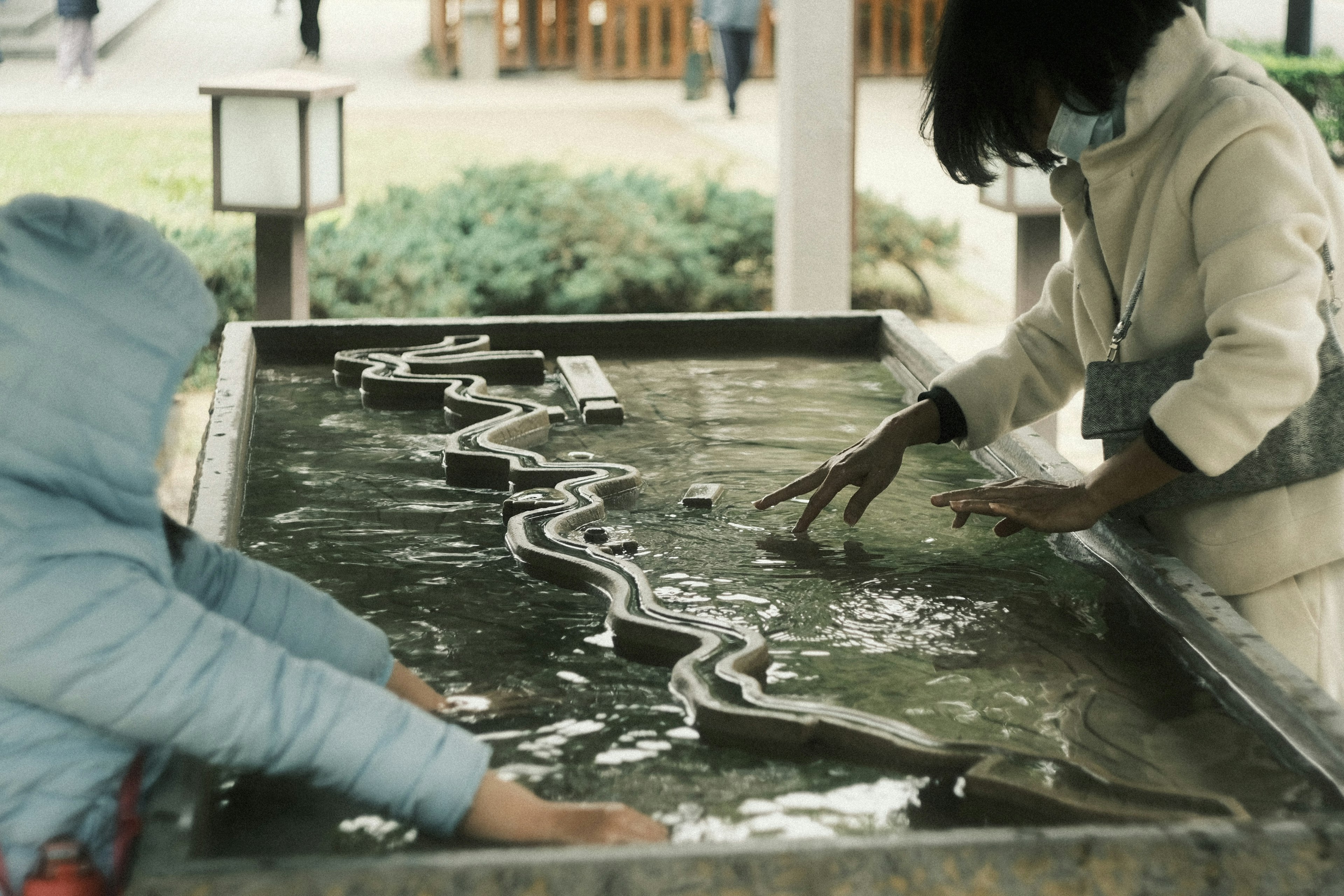 水の流れを模した遊び場で遊ぶ子供たち